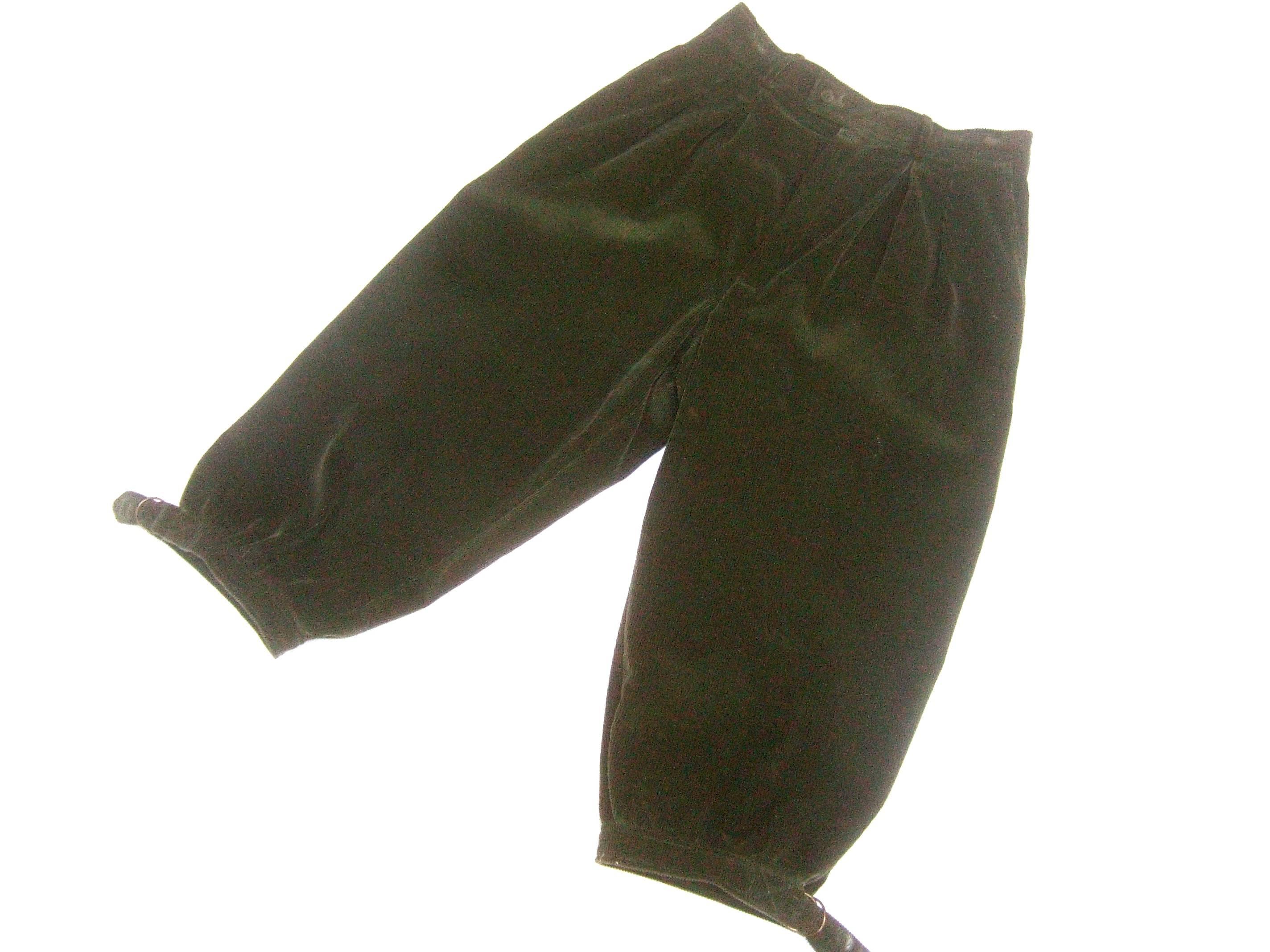 Saint Laurent Rive Gauche Moss green corduroy knicker slacks c 1970s  
The stylish cotton corduroy knicker style slacks are designed
with subtle pleating across the front 

The leg openings have a partial slit paired with copper tone
metal buckles