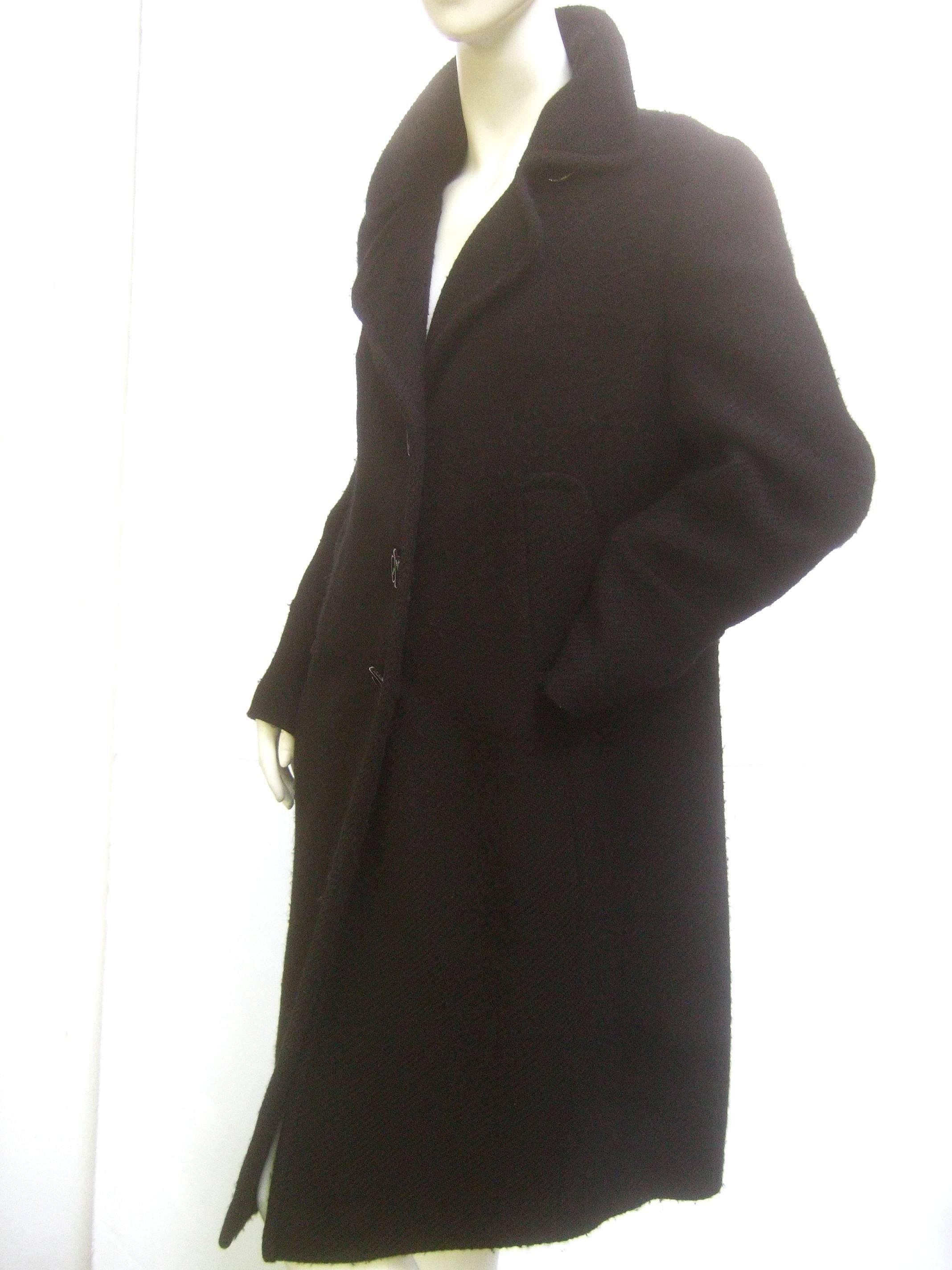 Akris Punto Classic black wool winter coat US Size 10
The stylish coat is designed plush laine wool 
Adorned with a trio of large black lucite buttons 

The liane wool shell has a very subtle diagonal stripe 
woven into the black on black wool