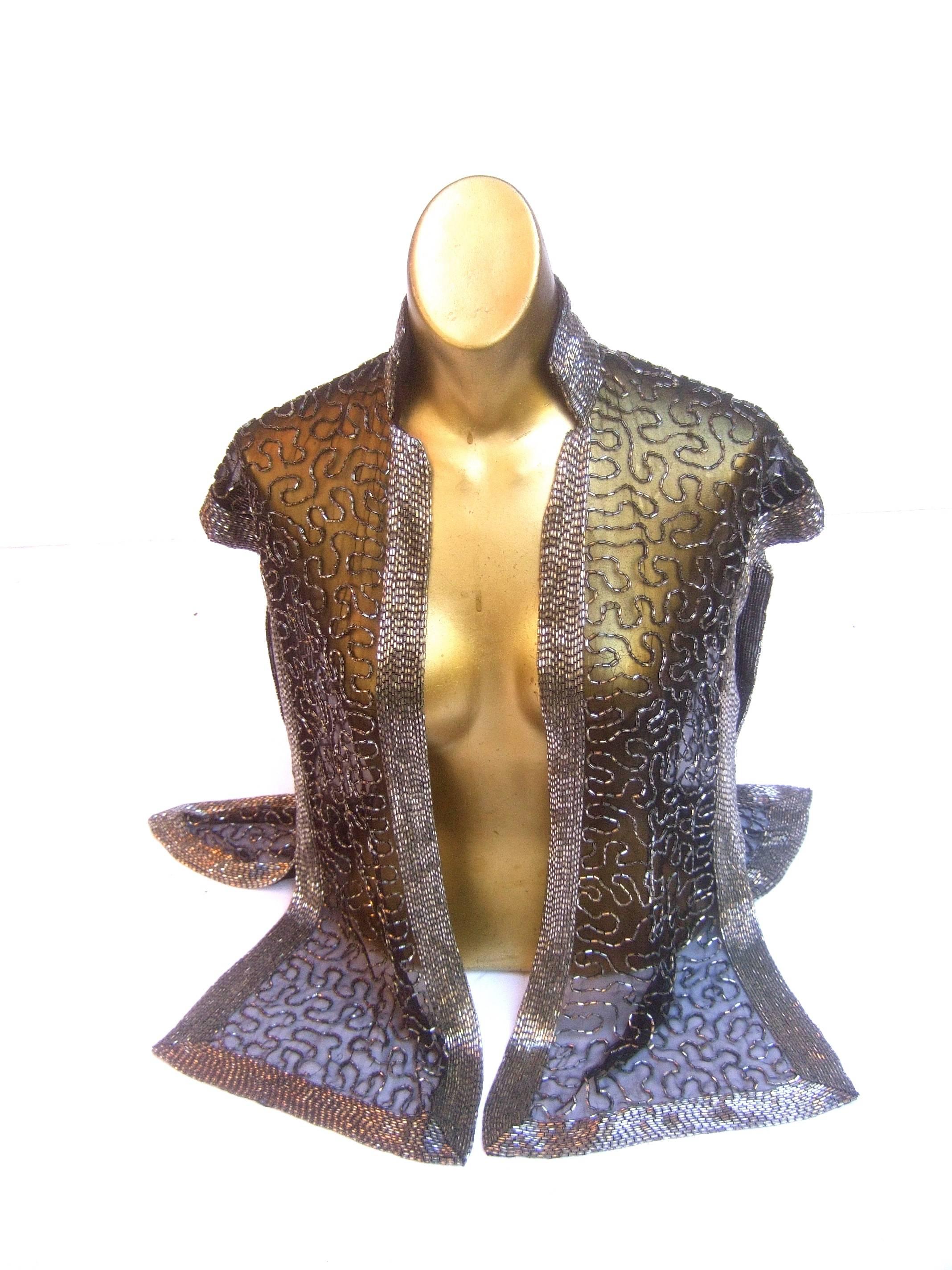 Exquisite silver glass beaded sheer vest c 1970s 
The elegant sheer black vest is embellished 
with sinuous trails of silver glass bugle beads

Framed with wide rows of contiguous silver
glass bugle beads. The elaborate glass beads
are substantial