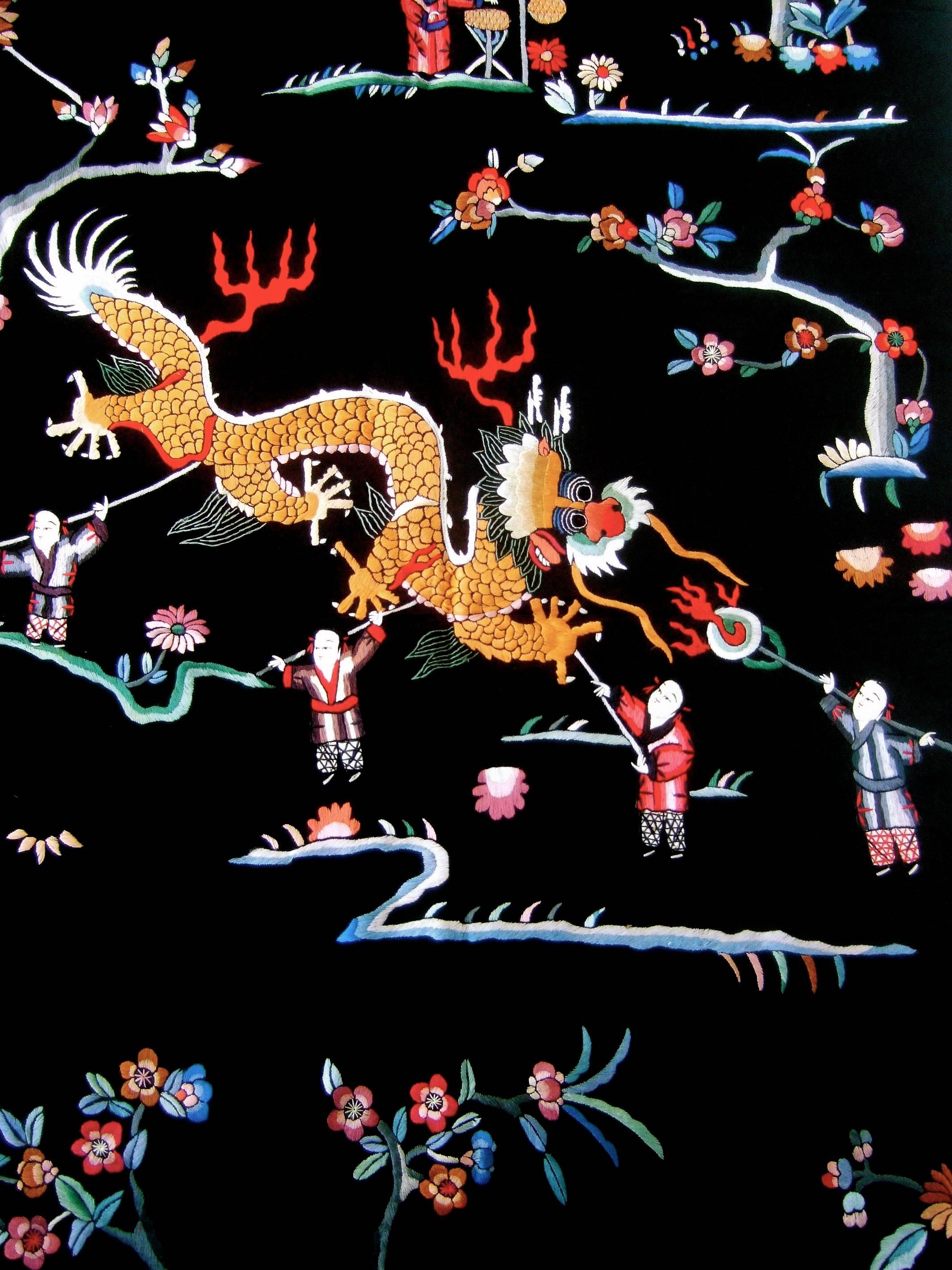 Exotic embroidered Asian theme pair of satin fabric panels c 1970s
The black satin panels are illuminated with intricate floral,
and figural hand embroidery 

Embellished with pair of mythical fire breathing dragons 
presiding over the garden of