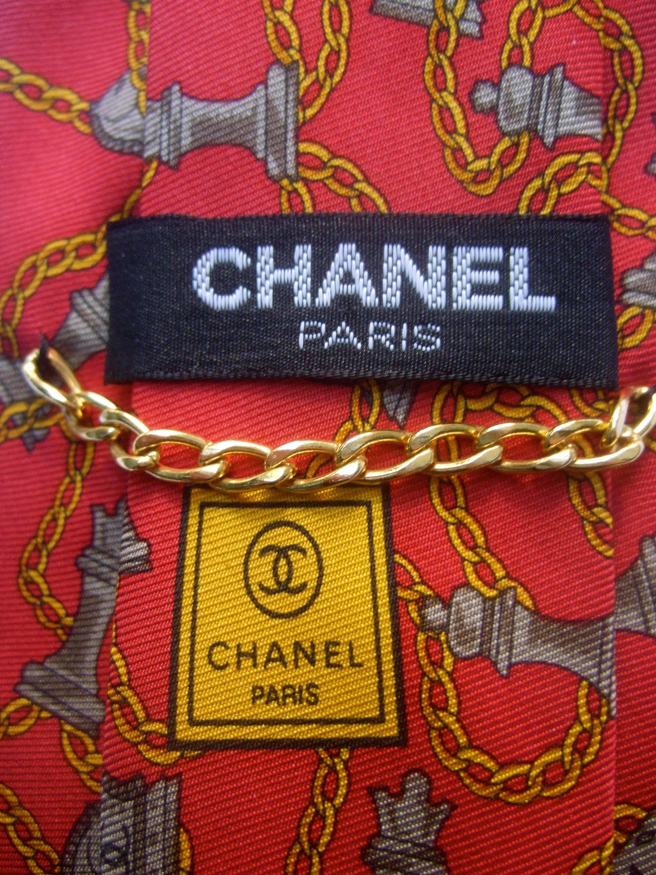 Chanel men's Italian silk chess theme necktie c 1990s
The stylish silk necktie is illustrated with a series 
of chess theme figures connected with sinuous
gold chain graphic

The horse figures have Chanel's C.C. initials 
The chess pieces and gold