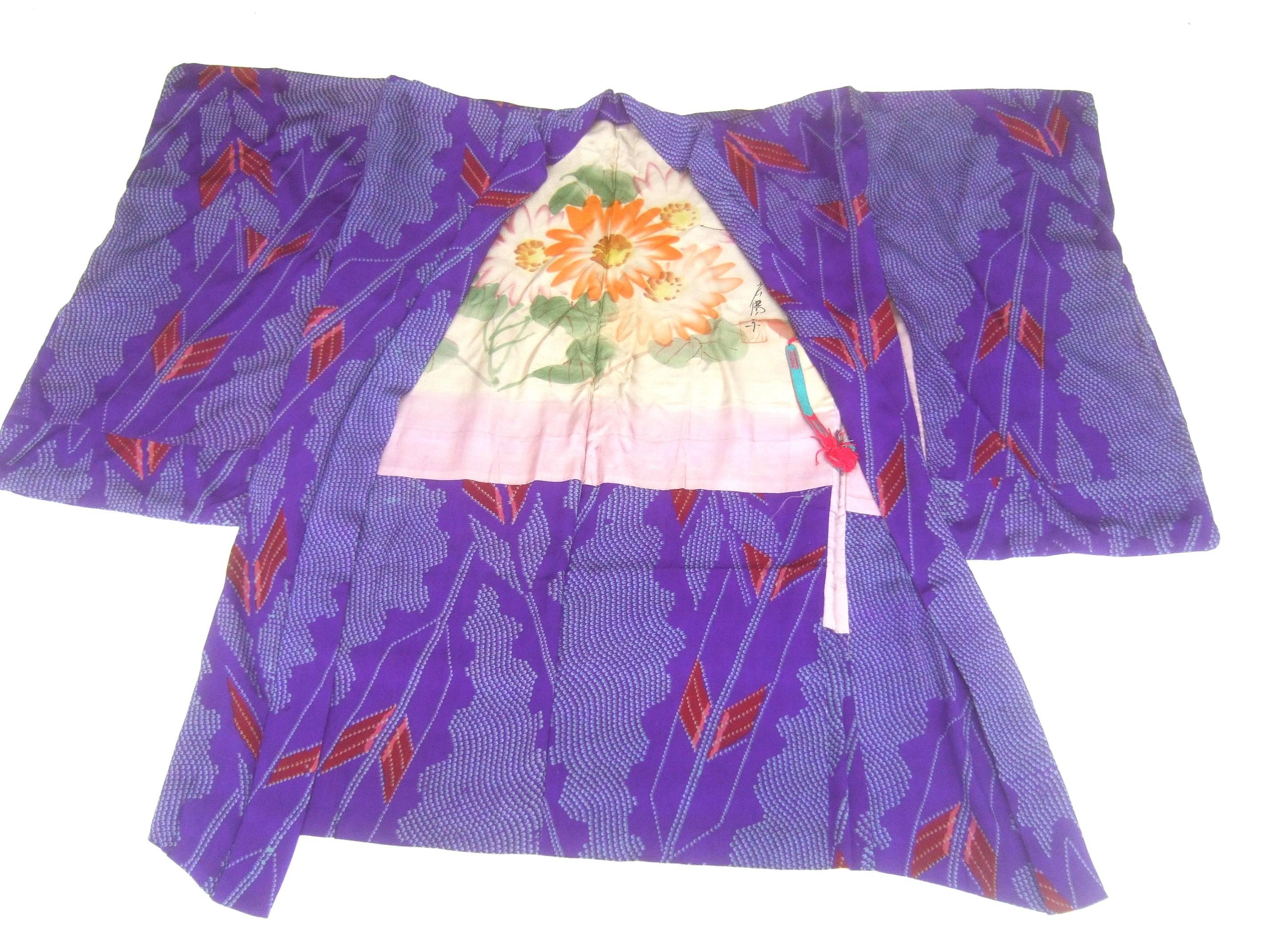 Japanese exotic silk print kimono jacket c 1970s
The vibrant graphic print kimono jacket is infused 
with abstract designs that are illuminated against 
a violet silk background 

The interior is partially lined with a silk panel 
with hand painted