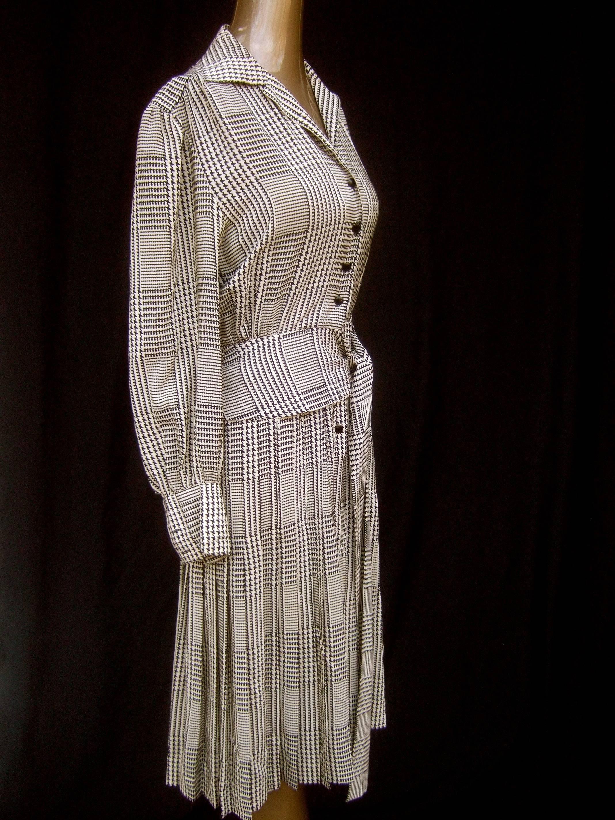 Saint Laurent Rive Gauche silk print belted houndstooth dress c 1980s
The elegant silk dress is designed with black graphics set against
a white silk background in various patterns 

Designed with a built in belt tie that cinches around the