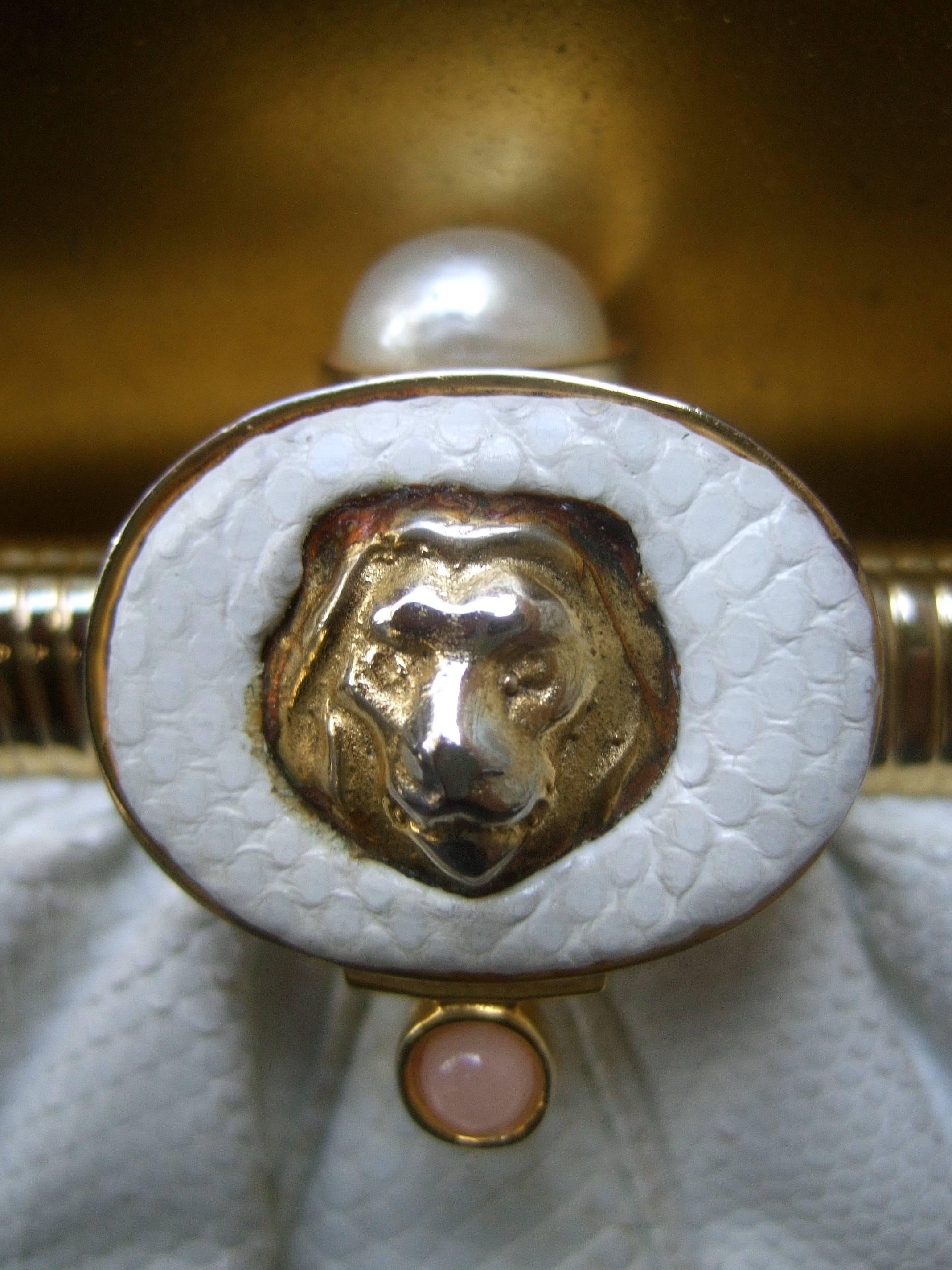 Judith Leiber Lion clasp embossed white leather handbag c 1980s
The elegant handbag is adorned with a gilt metal lion's head
emblem that serves as the clasp emblem. Accented with a glass
enamel pearl and tiny pink glass cabochon 

The versatile