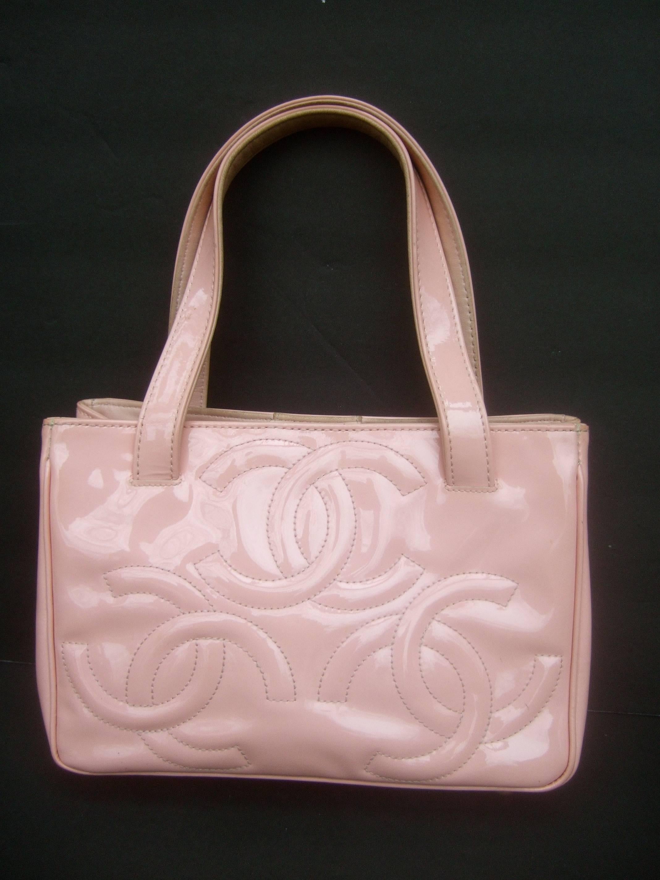 Chanel pink patent leather handbag in Shabby Chic AS IS Condition 
The pale pink patent leather handbag is designed with three sets
of Chanel's iconic large scale initials on both exterior sides

One of the exterior sides has several darkened spots