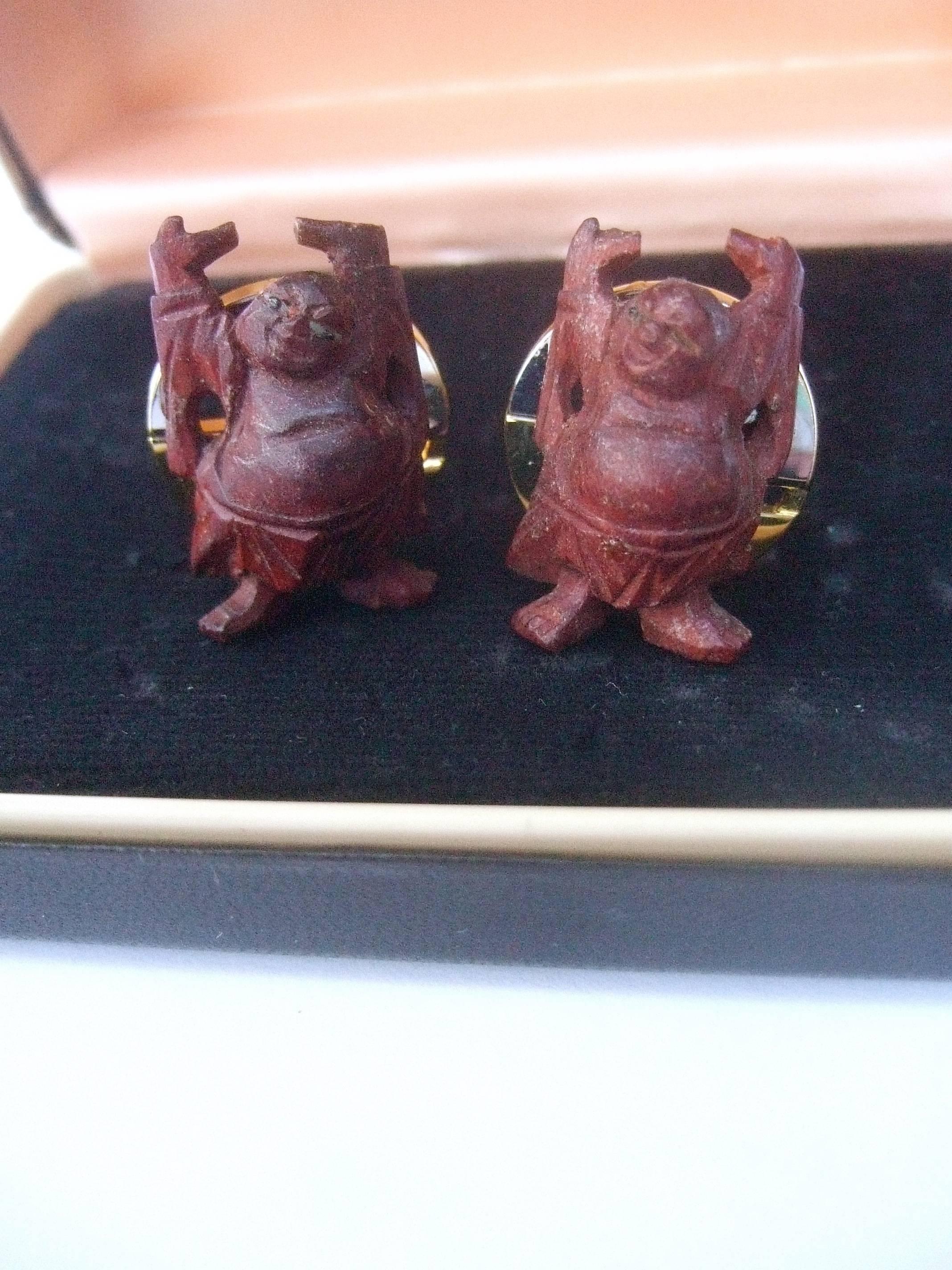 Pierre Cardin carved wood buddha cufflinks in Pierre Cardin box c 1970s 
The unique figural cufflinks are carved in the shape of buddha figures
The buddha figures are mounted on gilt metal cufflink backings
Each of the cufflinks is inscribed with