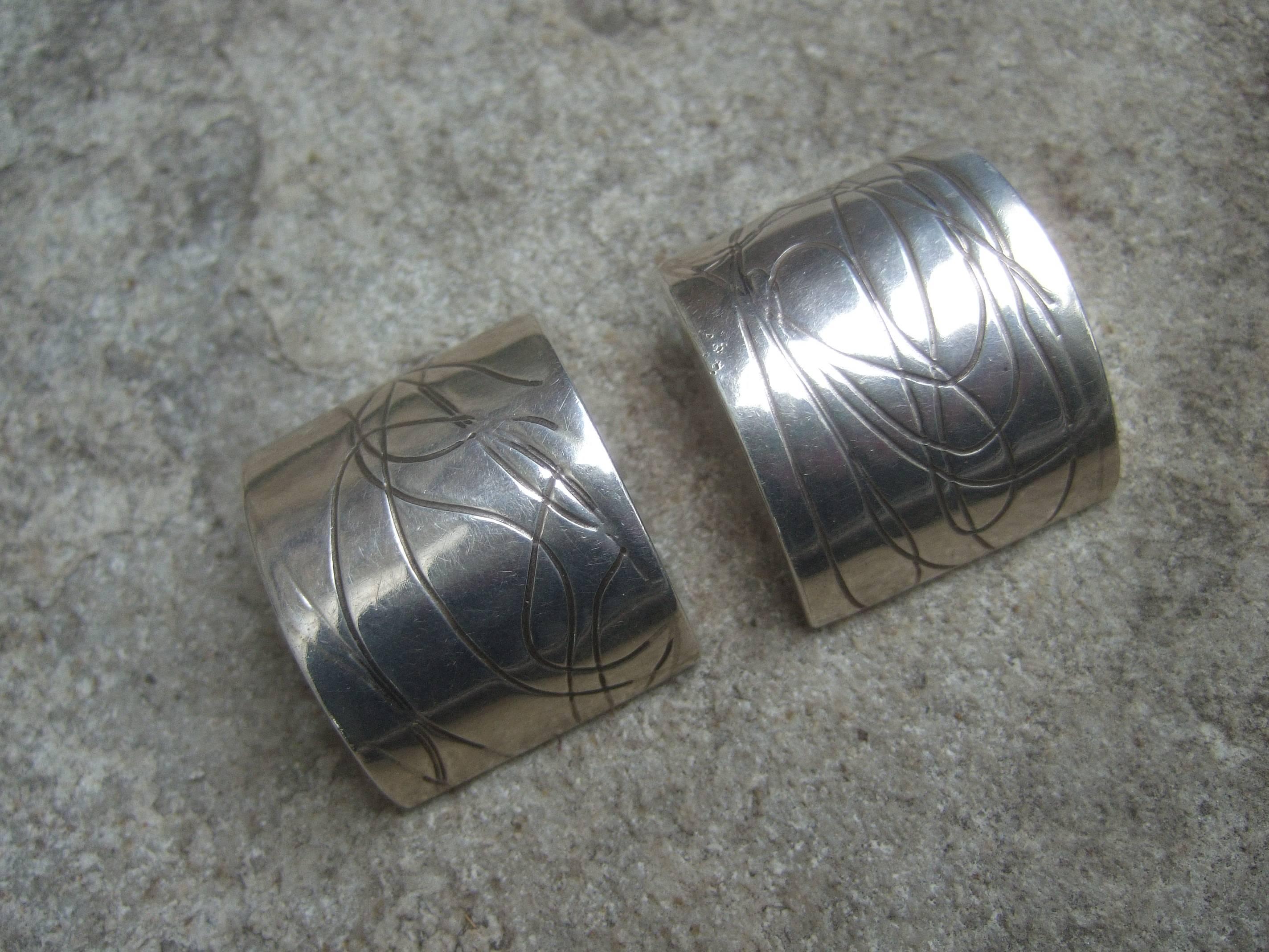 Sterling artisan clip on statement earrings c 1990s 
The chunky dome shaped clip on sterling earrings
have sinuous etched designs 

The back of each ear clip is stamped sterling 
The back of each earring is inscribed Koplewitz 

The chunky sterling