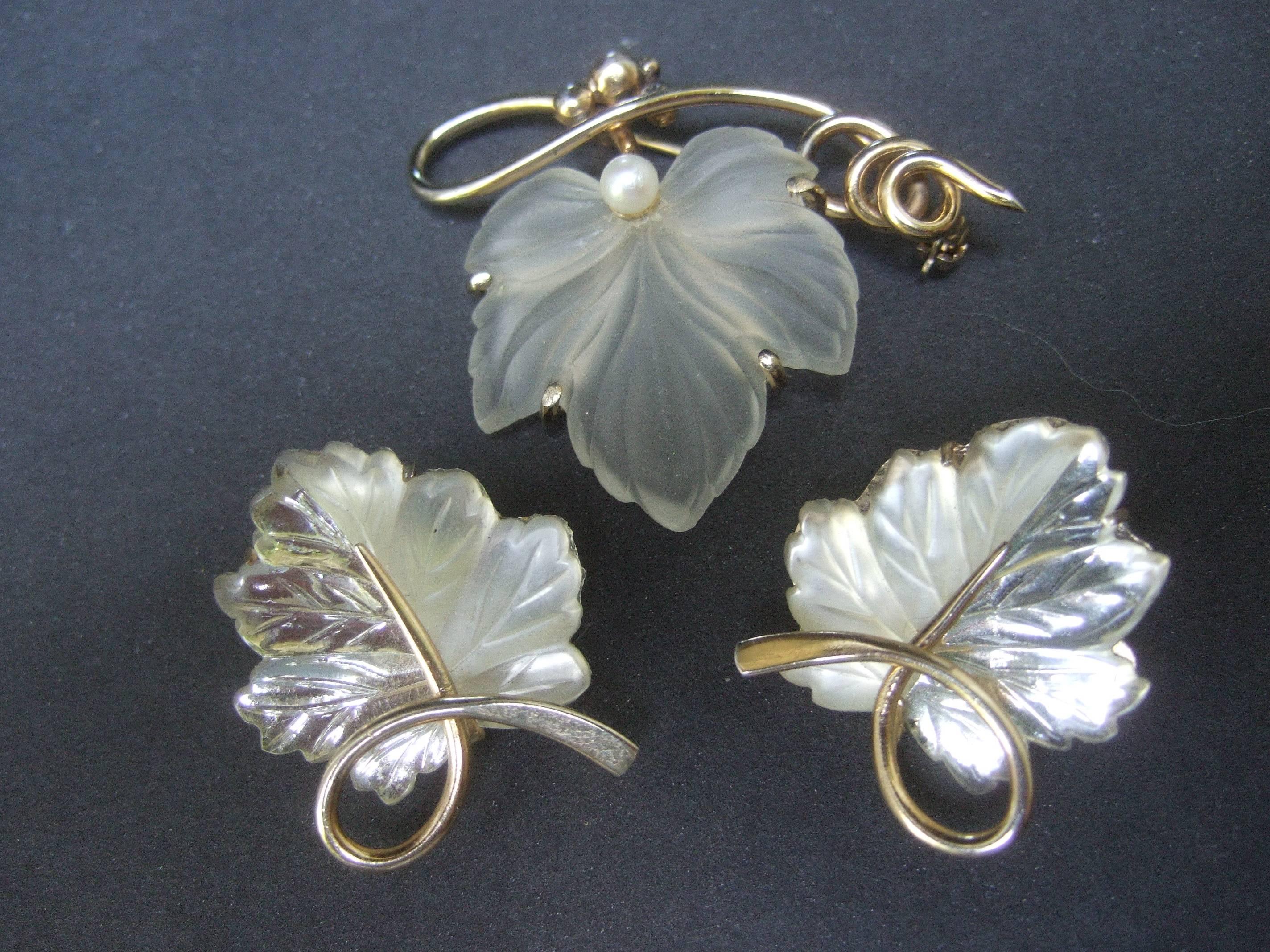 Napier sterling silver frosted glass leaf brooch & earrings c 1960
The elegantly refined brooch is designed with opaque
molded glass leaf 

The frosted glass leaf is paired with a sinuous sterling 
silver band. Embedded at the base of the leaf
