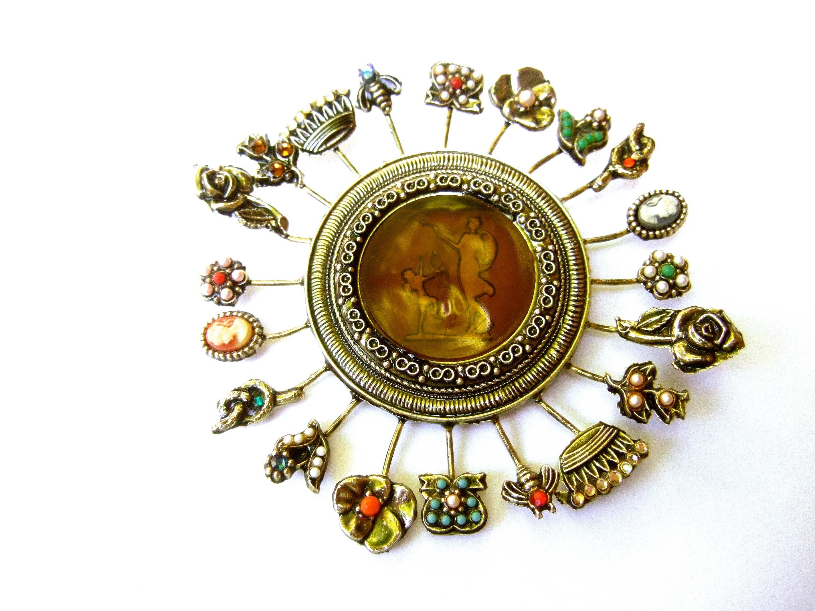 Massive circular medallion lucite intaglio brooch c 1970s
The unique large-scale brooch is designed with a collection
of tiny charm medallions; crowns, flowers bees, serpents and 
cameo silhouettes. The tiny medallions are embellished 
with glass