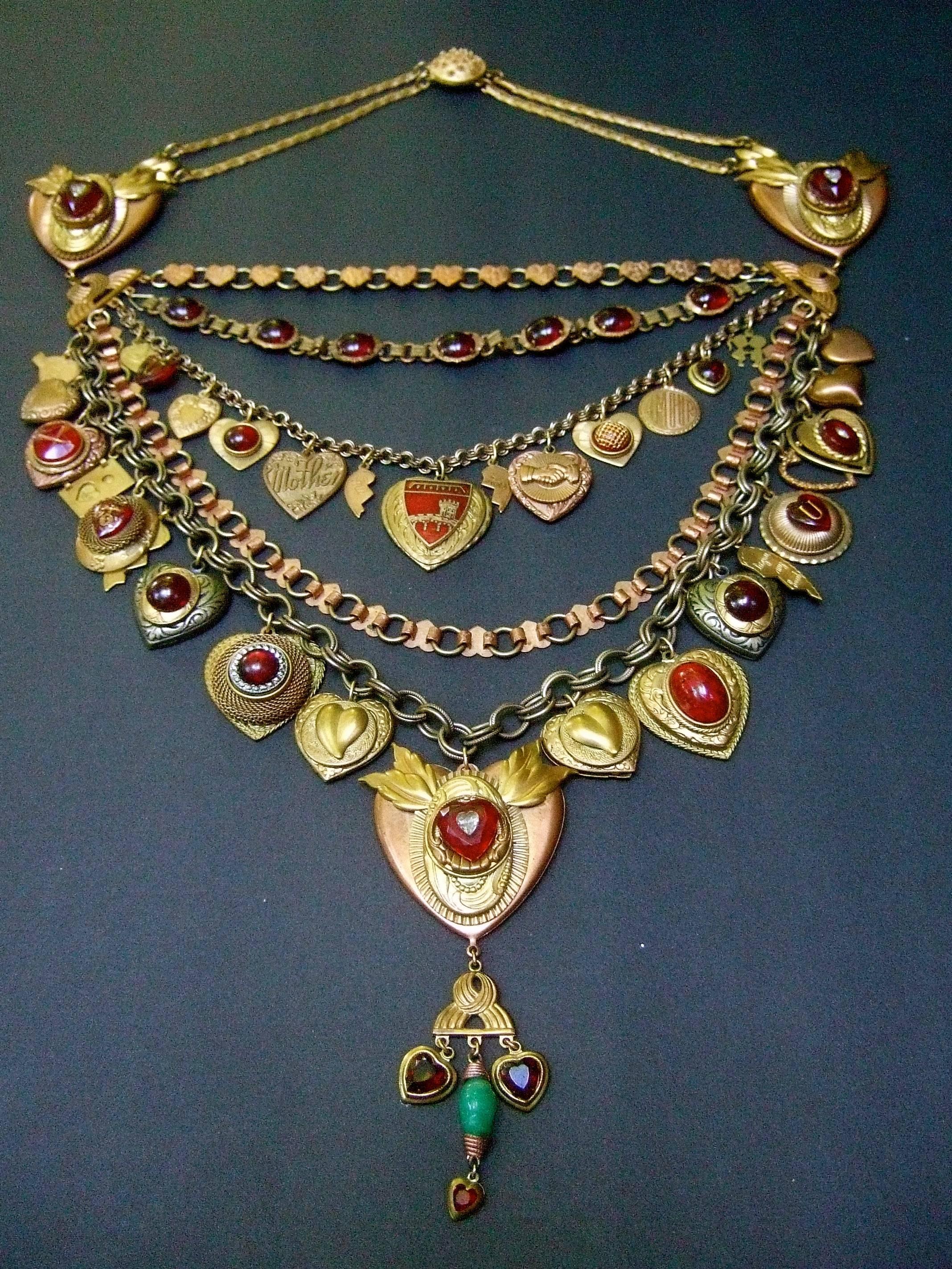 Massive artisan heart medallion charm necklace c 1980s
The handmade bib style necklace is embellished with a collection
of heart theme charms in various shapes, styles and metals   

The unique artisan necklace is designed with copper
tone and brass