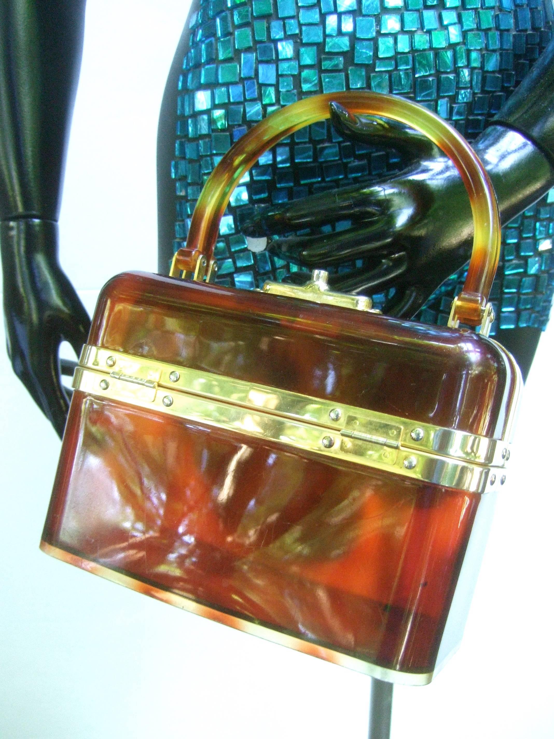 1970s Sleek French tortoise shell lucite box purse 
The mod retro handbag is constructed with brown
honey color translucent lucite panels 

Framed with polished gilt metal hardware designed
with a pair of lucite swivel handles 
The top opening is