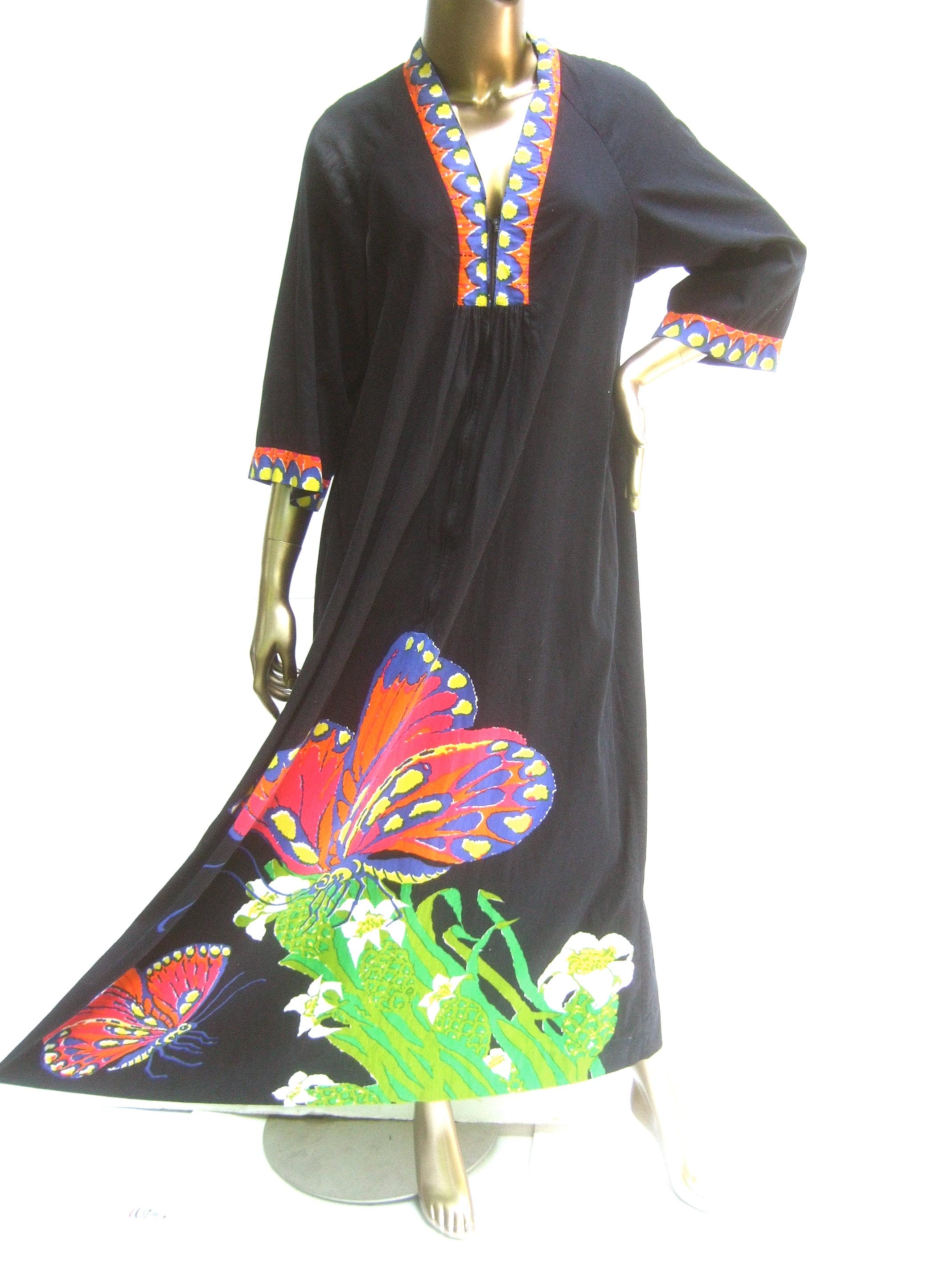 Neiman Marcus Mod cotton butterfly graphic print caftan c 1970s 
The chic retro black cotton caftan is designed with a pair 
of large-scale color block butterflies on both the lower
front section and is replicated on the back side 

The neckline and