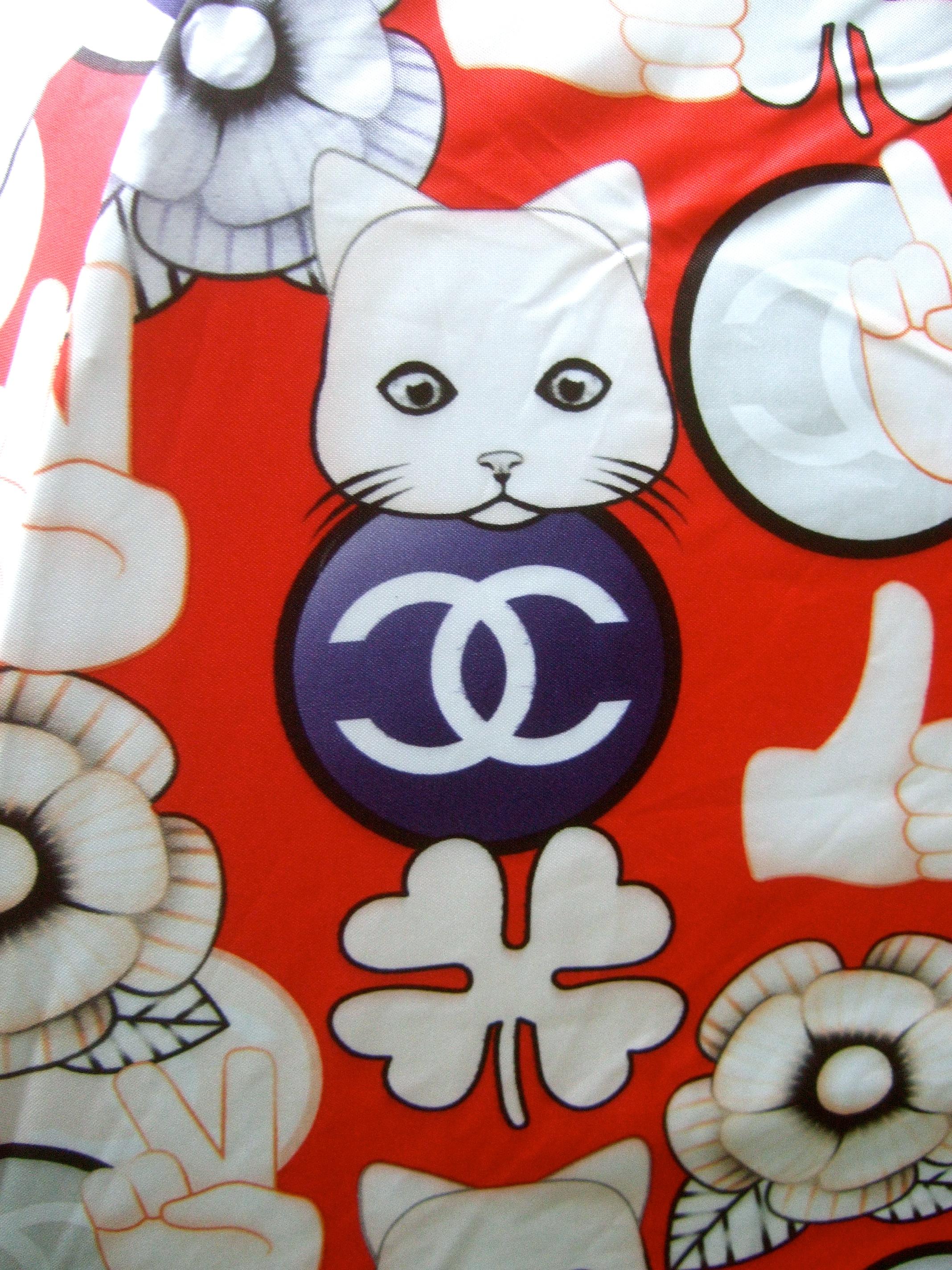 Chanel cat theme umbrella in Chanel presentaion box 21st C 
The charming red nylon umbrella is desigend with endearing
cat faces, four leaf clovers, camellia flowers, hand symbols
and Chanel circular logos with their iconic interlocked 
C.C.