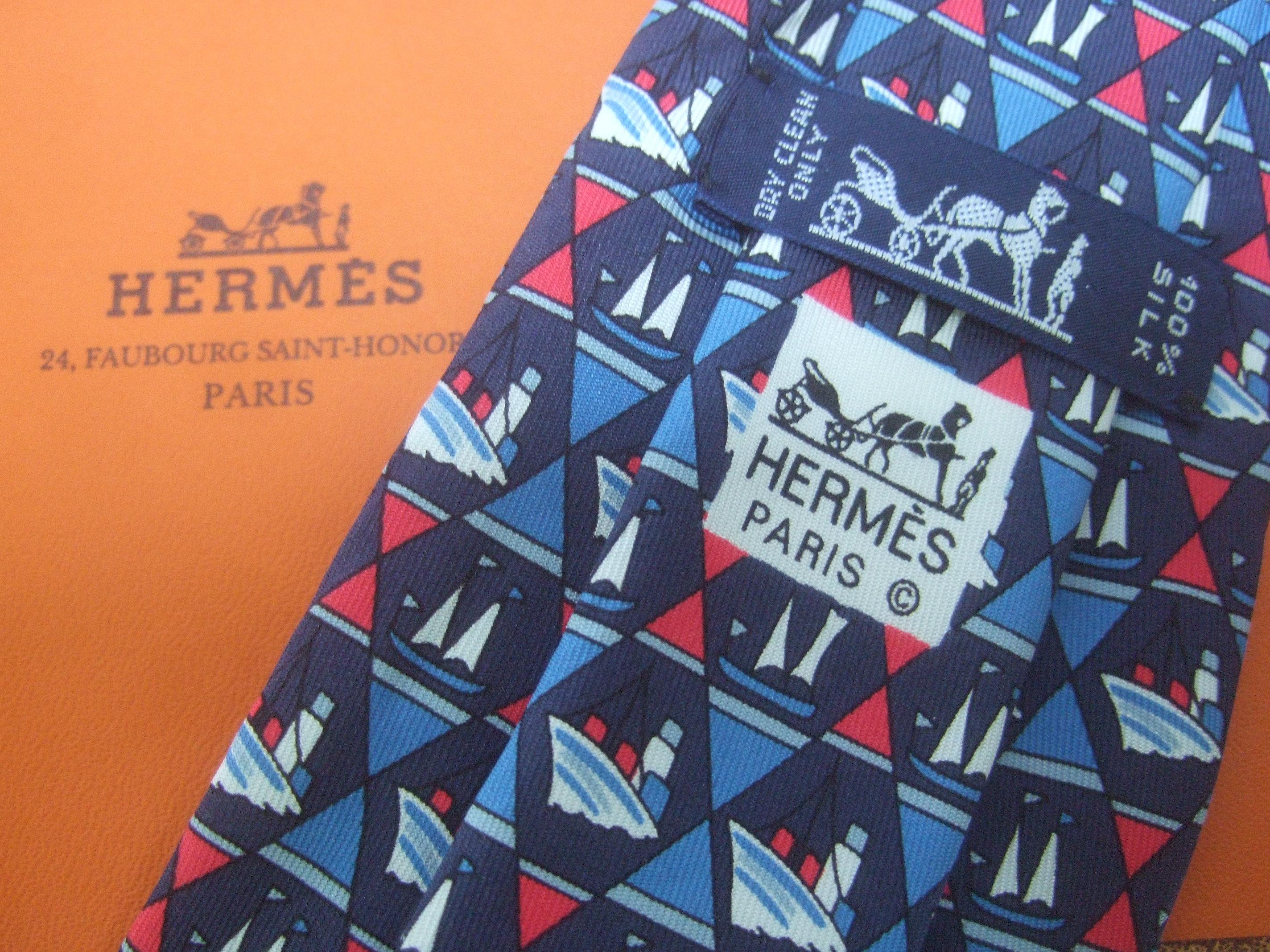 Hermes Paris Nautical sailboat silk necktie in Hermes box c 1990s
The stylish necktie is designed with a collection of sailboats
and sailing ships in a geometric diamond pattern 

The series of sailboats are illuminated with red, white and
blue