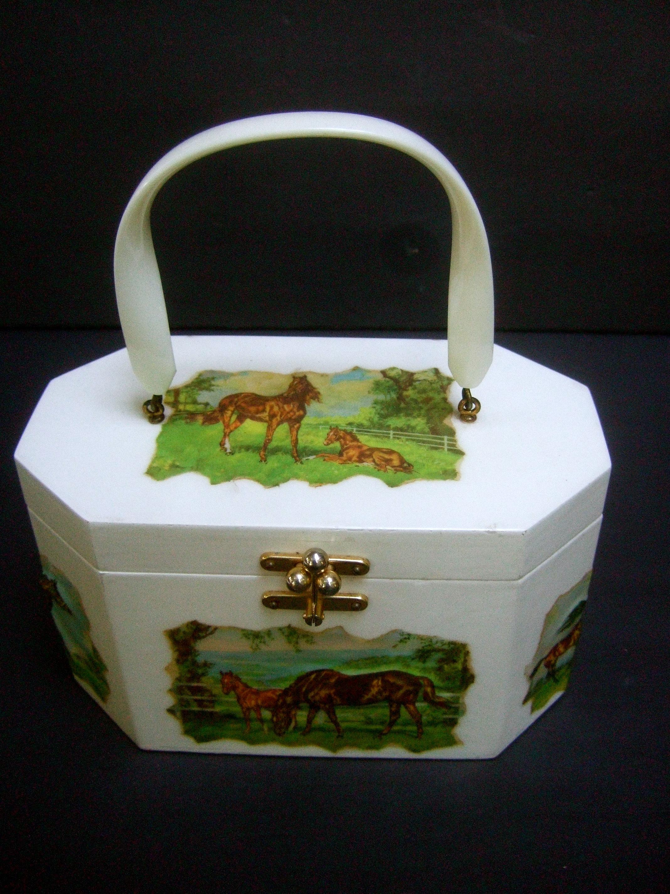 1970s Equine decoupage box purse designed by Annie Laurie Palm Beach 
The unique white enamel wood box purse is decorated with a collection
of decoupage horse scenes in a myriad of outdoor settings 

The octagon-shaped purse is carried with a white