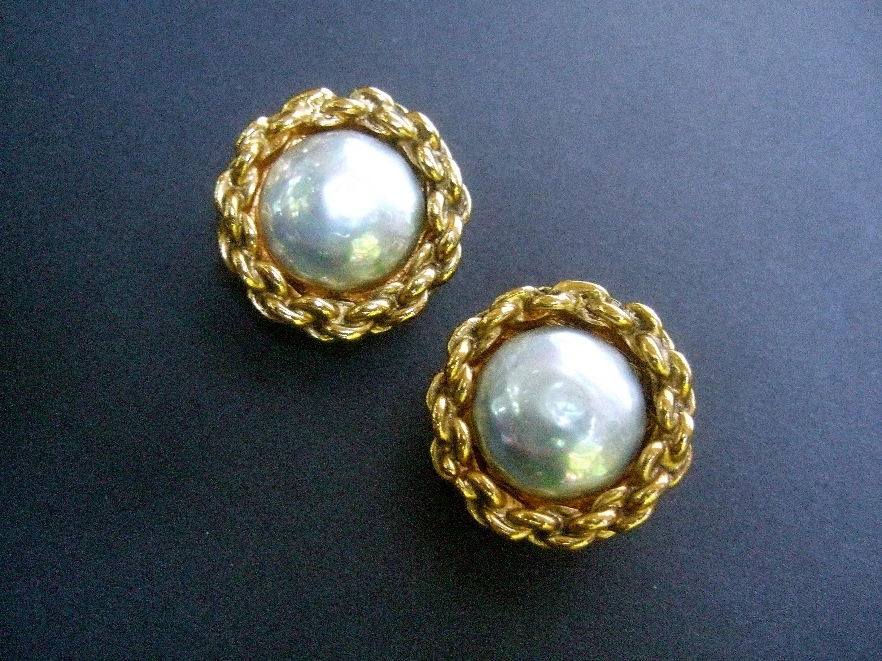 Chanel glass enamel pearl gilt button clip on earrings c 1990s
The classic Chanel glass enamel pearl clip-on earrings
are framed with a gilt metal chain border 

They make an elegant timeless accessory
The back of each earring is stamped: Chanel