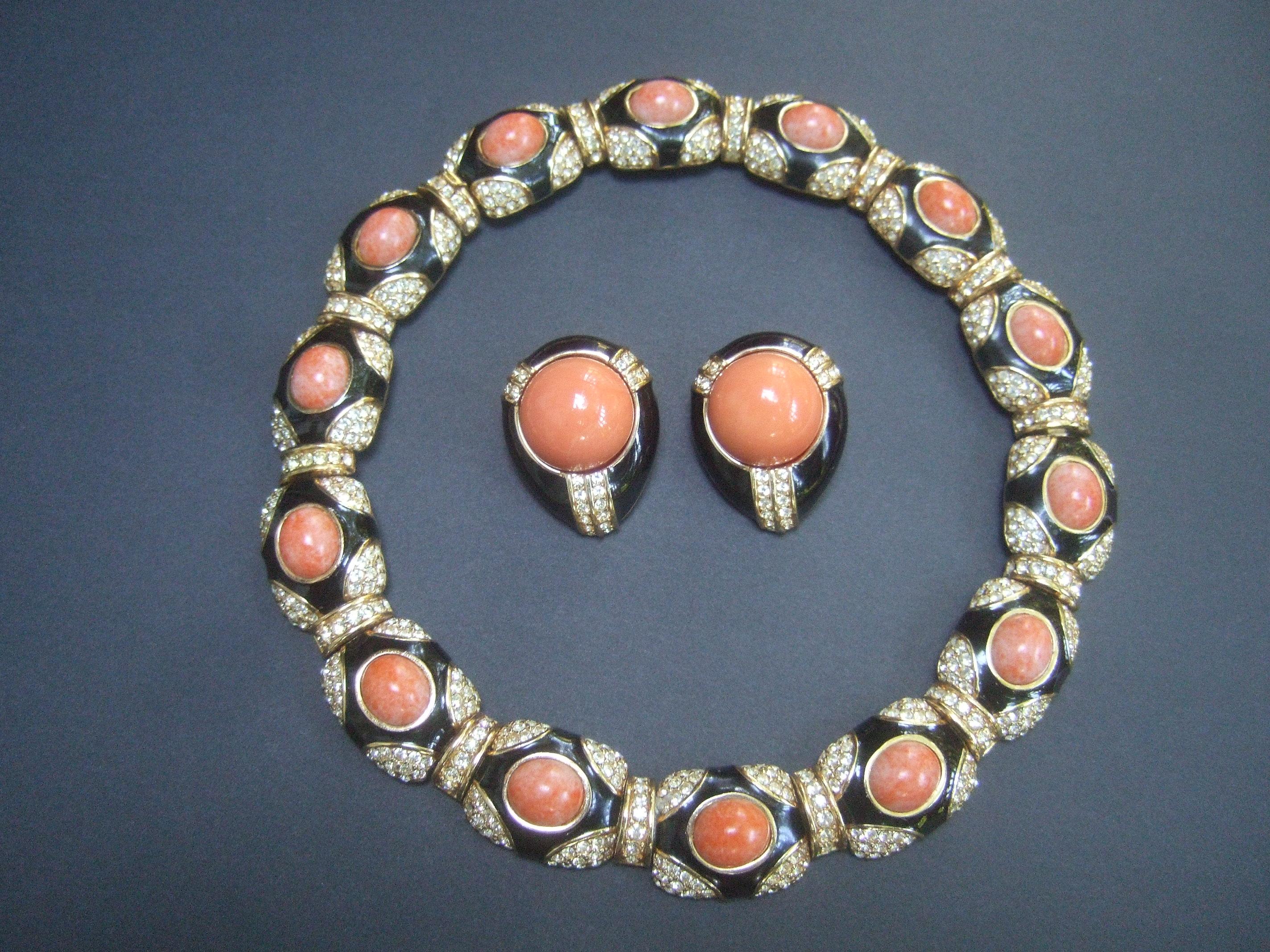 Ciner exquisite coral resin jeweled choker & earring ensemble c 1980s
The elegant choker necklace & clip-on earrings are embellished
with faux coral resin cabochons, black enamel lacquer with pave 
crystals set in gilt metal 

The articulated hinged