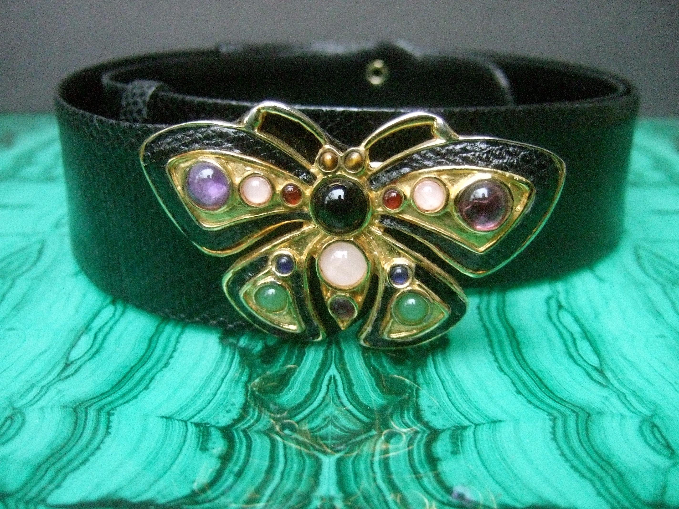 Judith Leiber Opulent jeweled glass black leather butterfly belt c 1980s
The elegant belt is designed with a butterfly buckle embellished
with a collection of pastel glass cabochons set in gilt metal 

The charming butterfly buckle is paired with an