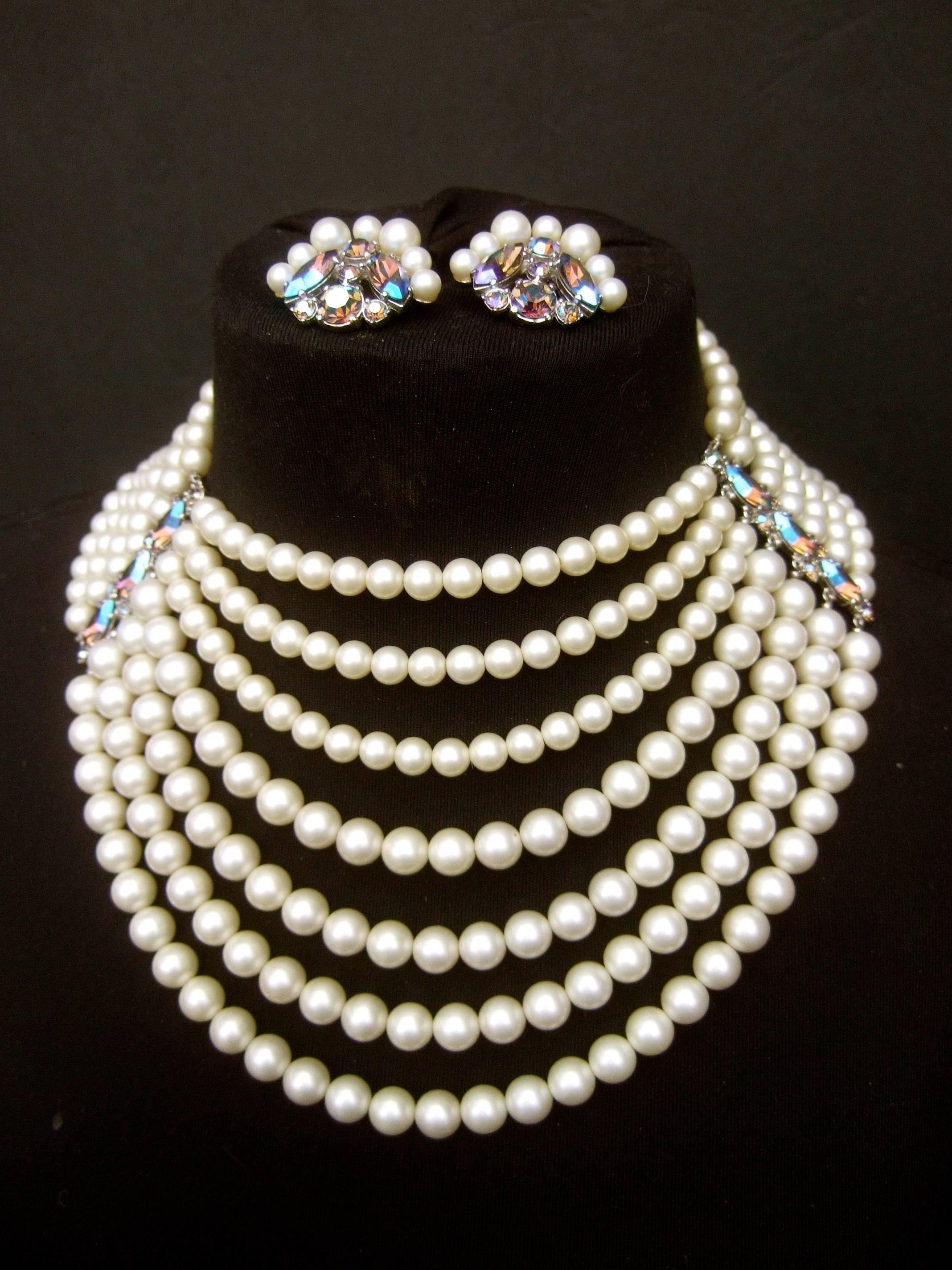 Schiaparelli dramatic multi strand faux pearl necklace - earring set c 1960s
The opulent faux pearl graduated seven strand necklace is designed
with resin enamel pearls. The striking costume necklace is embellished 
with a bar of aurora borealis