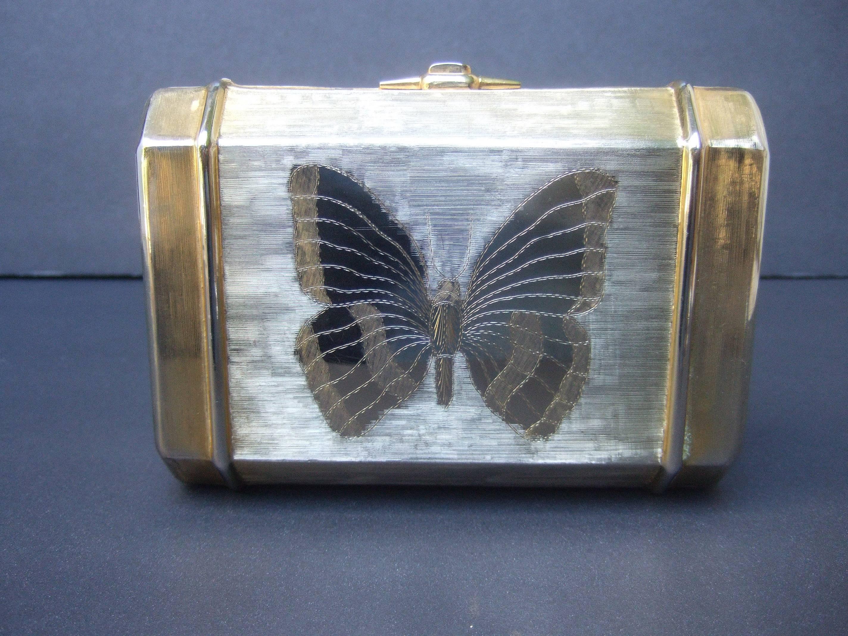 Saks Fifth Avenue Opulent gilt metal evening bag 
The elegant gold metal purse is adorned with an
etched butterfly on both exterior panels

The gold metal covering has a brushed satiny finish
The butterfly in contrast has smooth polish gold