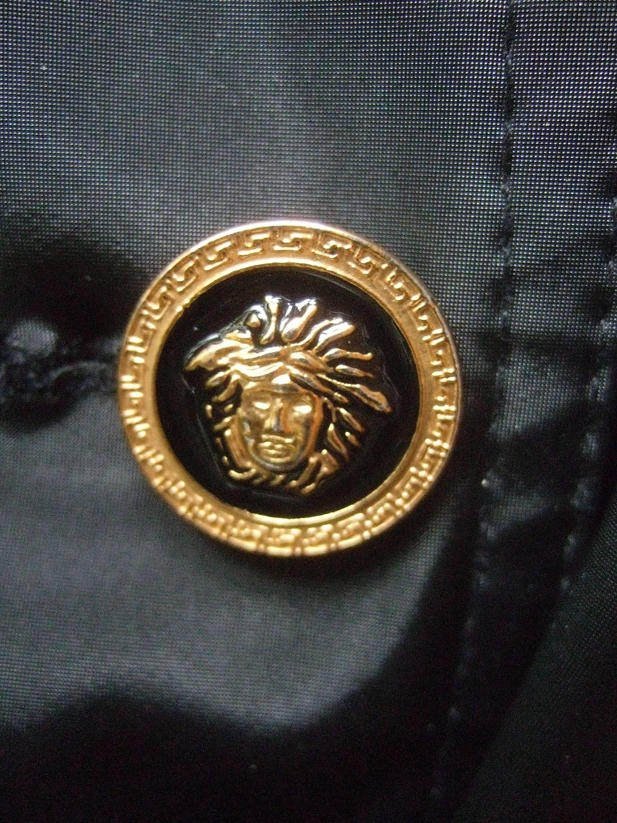 Versace Jeans Couture Sleek black all weather belted jacket  Size L
The stylish water repellent belted heavy gauge nylon jacket
is adorned with four gilt metal enamel medusa head buttons

The designer jacket has two front slash pockets
The