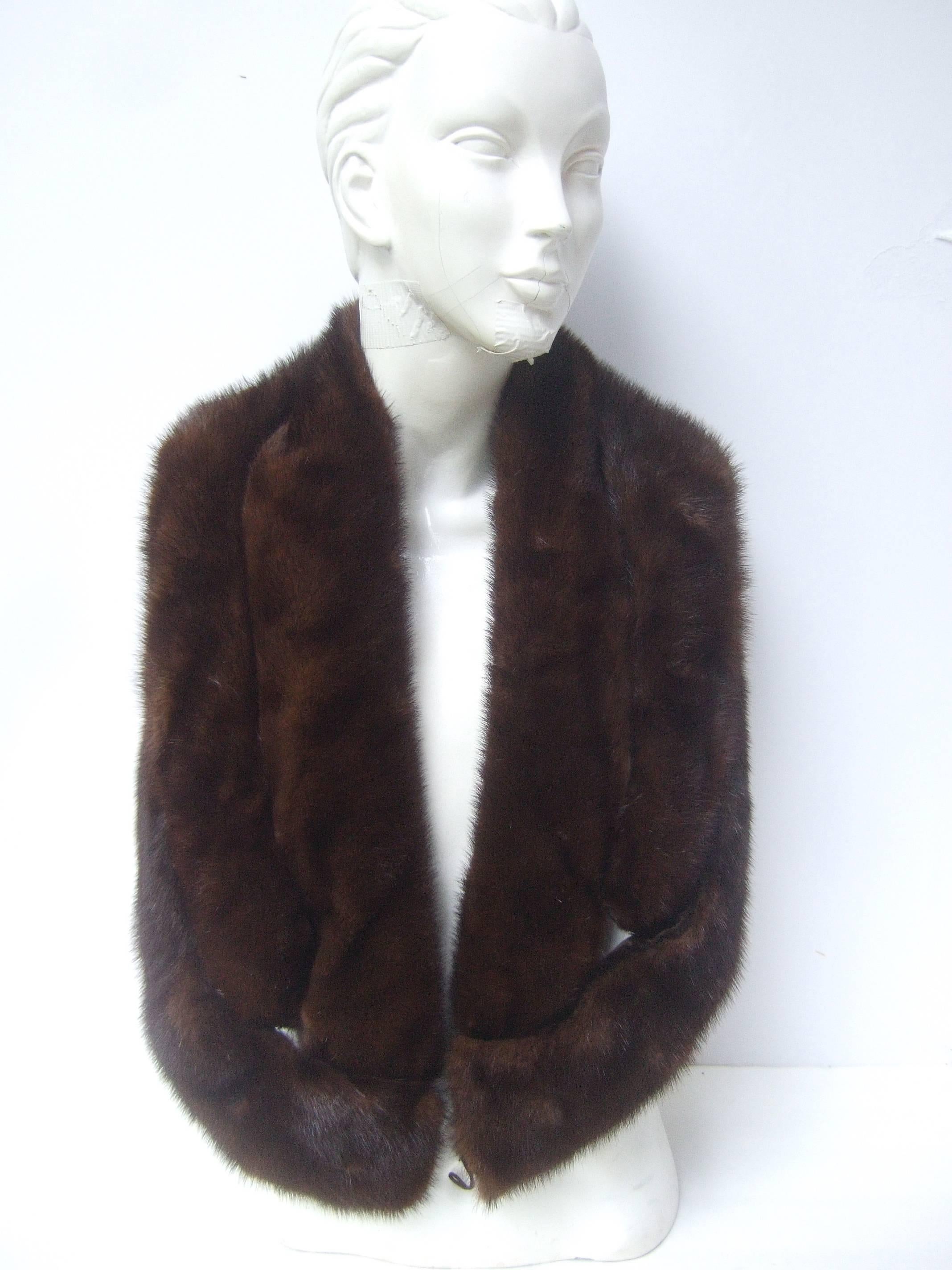 Luxurious plush triple band mink shrug c 1960
The chic mahogany ranch mink shrug
is designed with three rows of soft mink
on both ends. The center section is designed
with two panels of mink fur 

The mink bands are backed with brown velvet