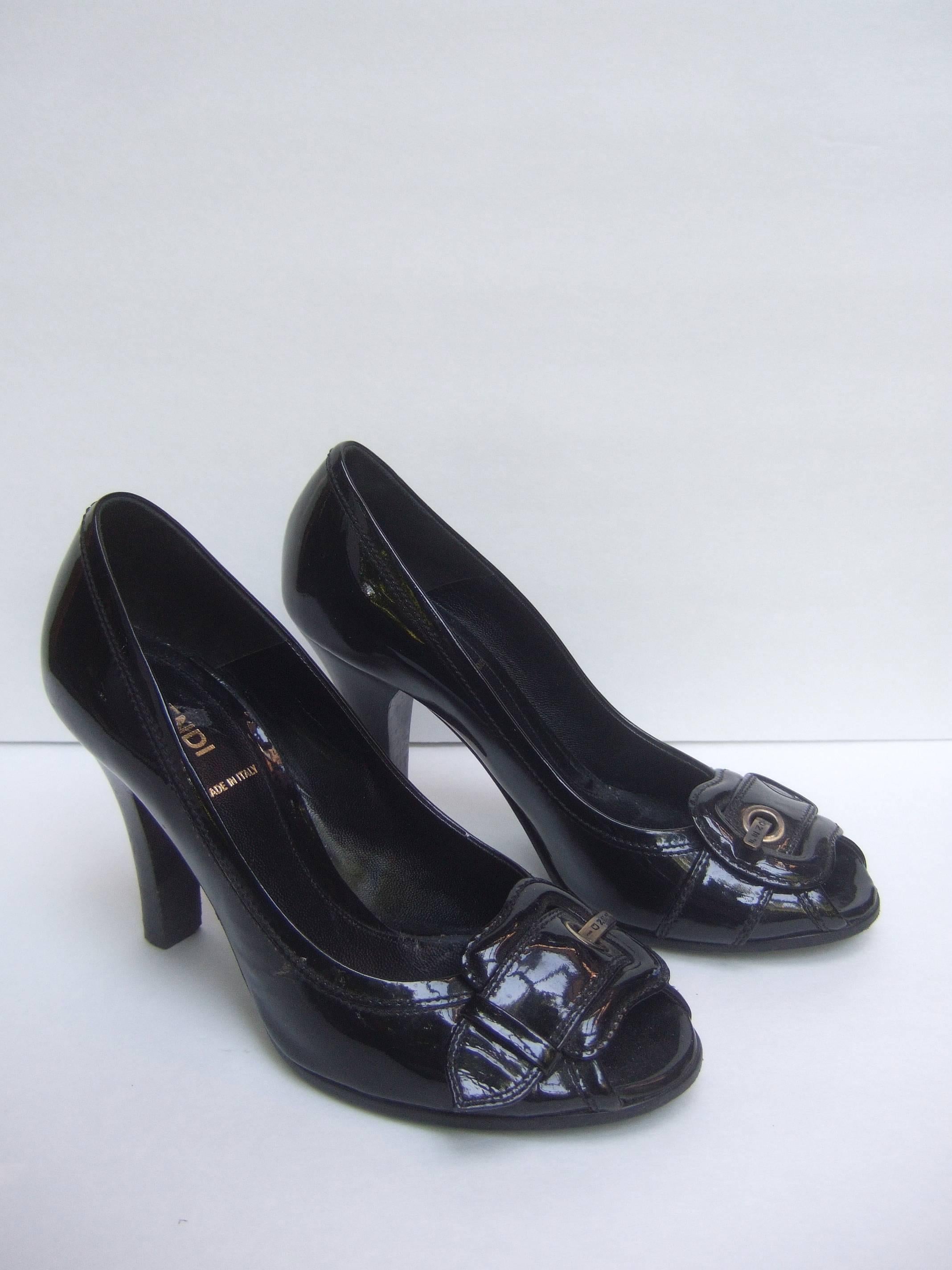 Fendi Italy Black patent leather buckle pumps 37.5
The stylish Italian pumps are covered with shiny
black patent leather

The peep toe pumps are accented with burnished
brass metal buckles stamped Fendi 

Stamped Fendi Made in Italy 
Size
