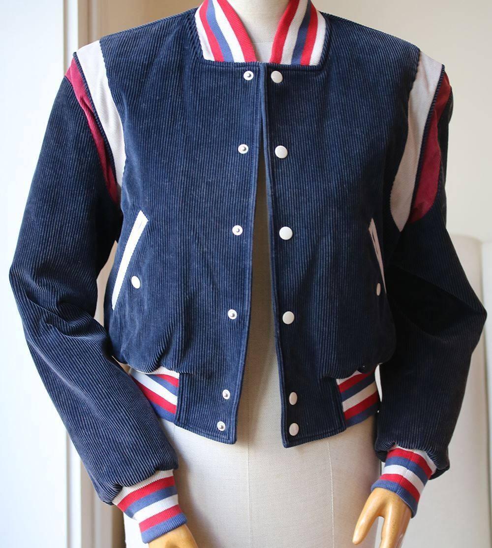 Gucci's bomber jacket, with its faded blue corduroy fabrication and athletic-inspired design, has throwback appeal. The back has been intricately embroidered with a snarling tiger head and the word 