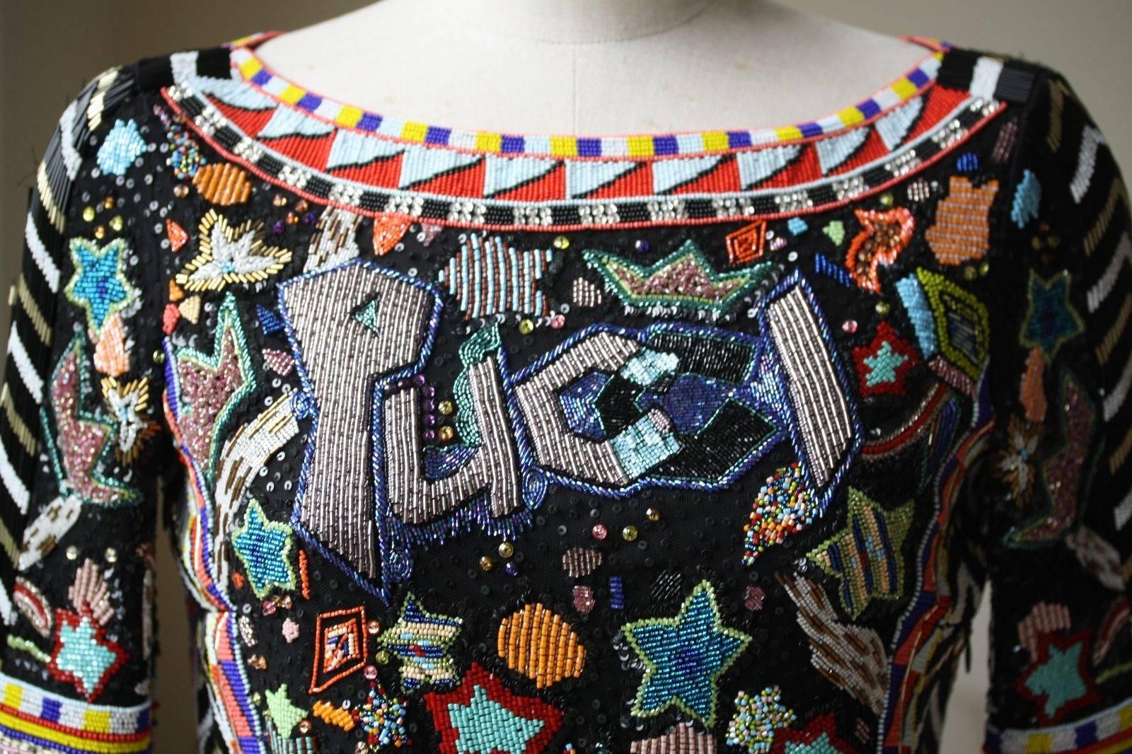 Pay homage to the exquisite look of Emilio Pucci with this bead embellished long sleeve sheath. Wide neckline, long sleeves, multicolored beading, cutout back with zip closure. Form-fitting. 

Size - IT 40 (UK 8, US 6, FR 36)

Condition: New without