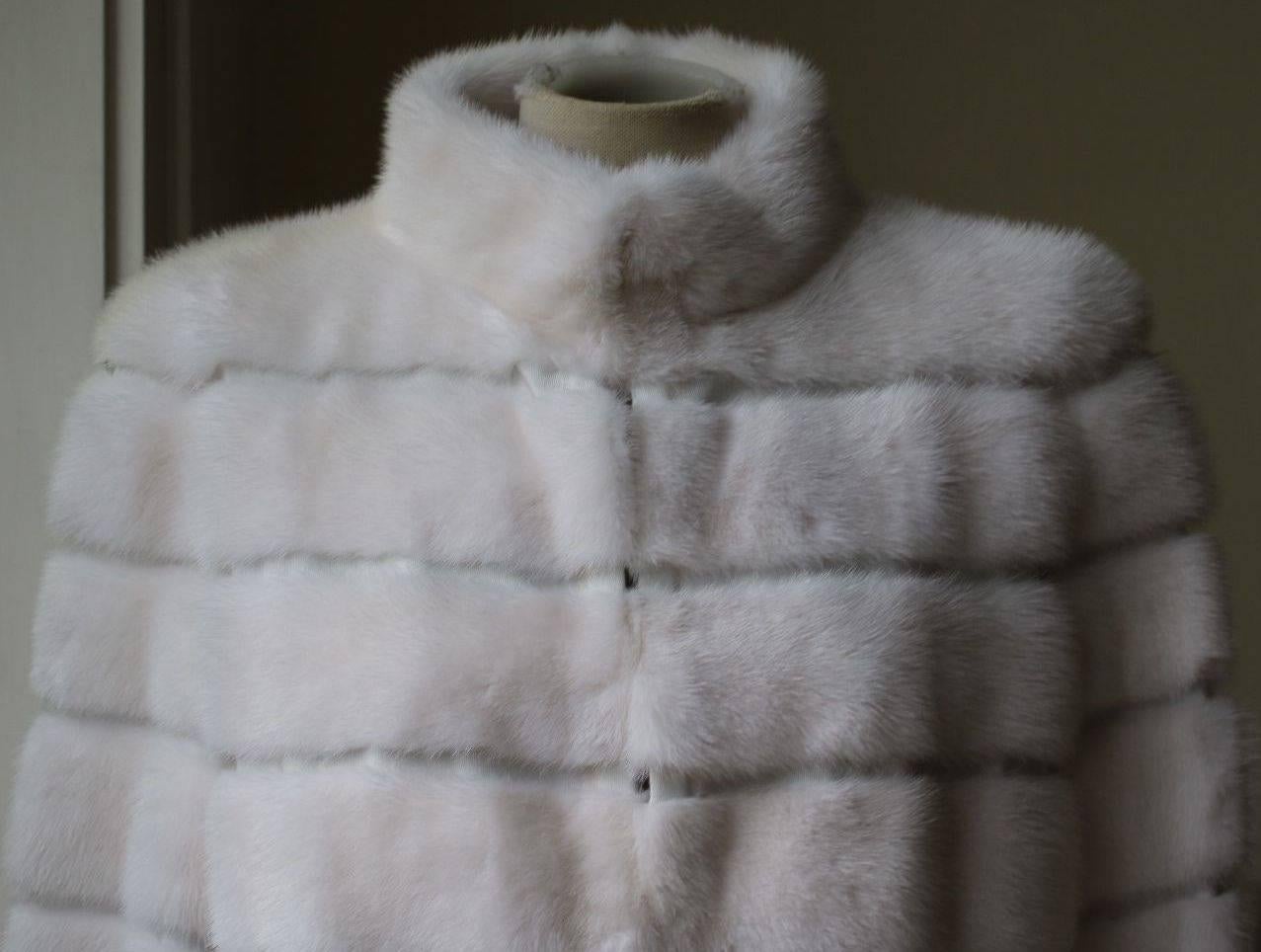 Snow white silk and mink fur coat from Fendi featuring a high standing collar, long sleeves and a concealed fastening. Summer/Spring lightweight fur. Unlined. 

Size: IT 42 (UK 10, FR 38, US 6)

Condition: As new condition, no sign of wear.