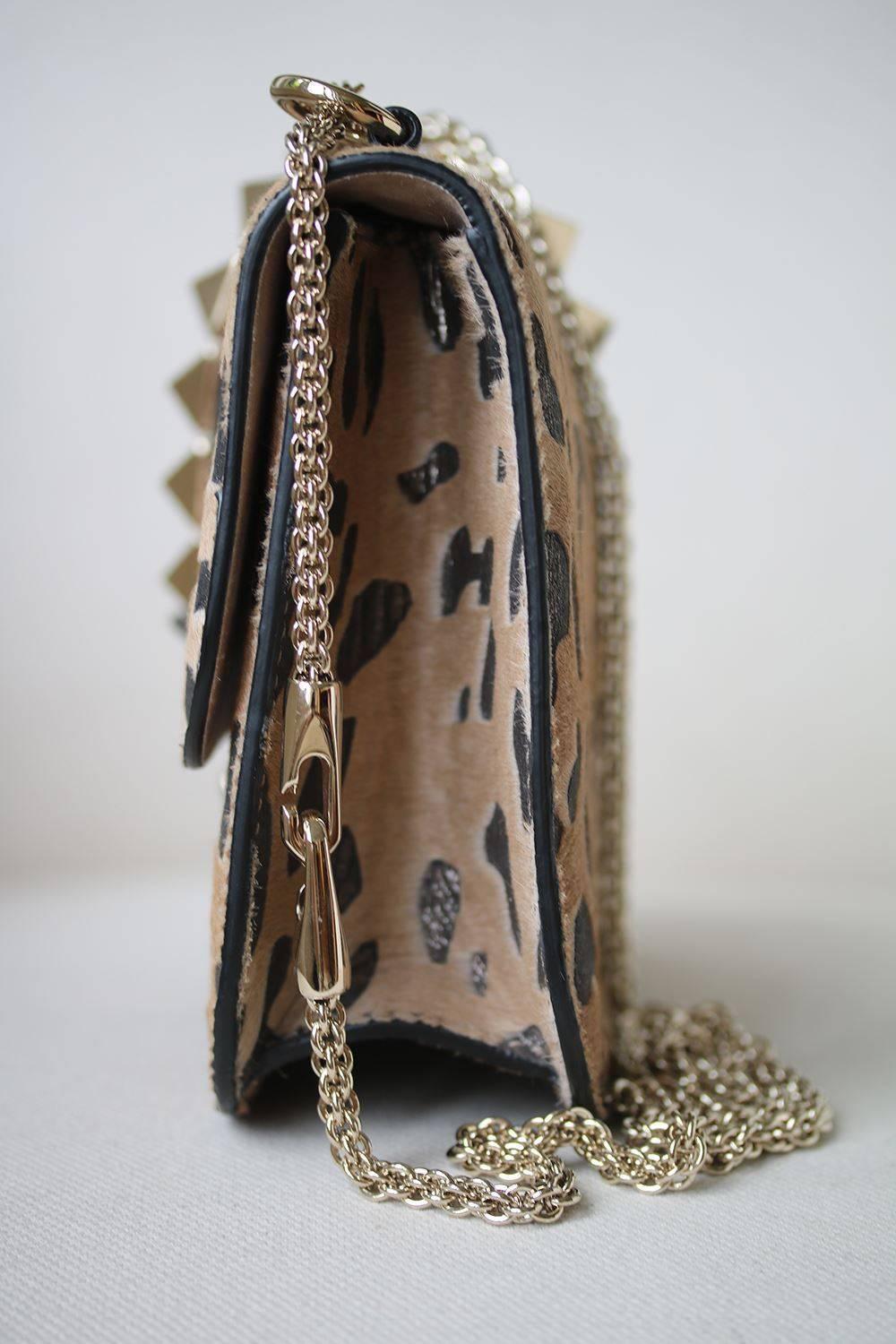 VALENTINO Calf Hair Leopard Print Medium Glam Lock Rockstud Flap Bag. This chic shoulder bag is crafted of calf hair and leather with a leopard print and pyramid studs over the top of the flap at the center of the bag. The bag features polished