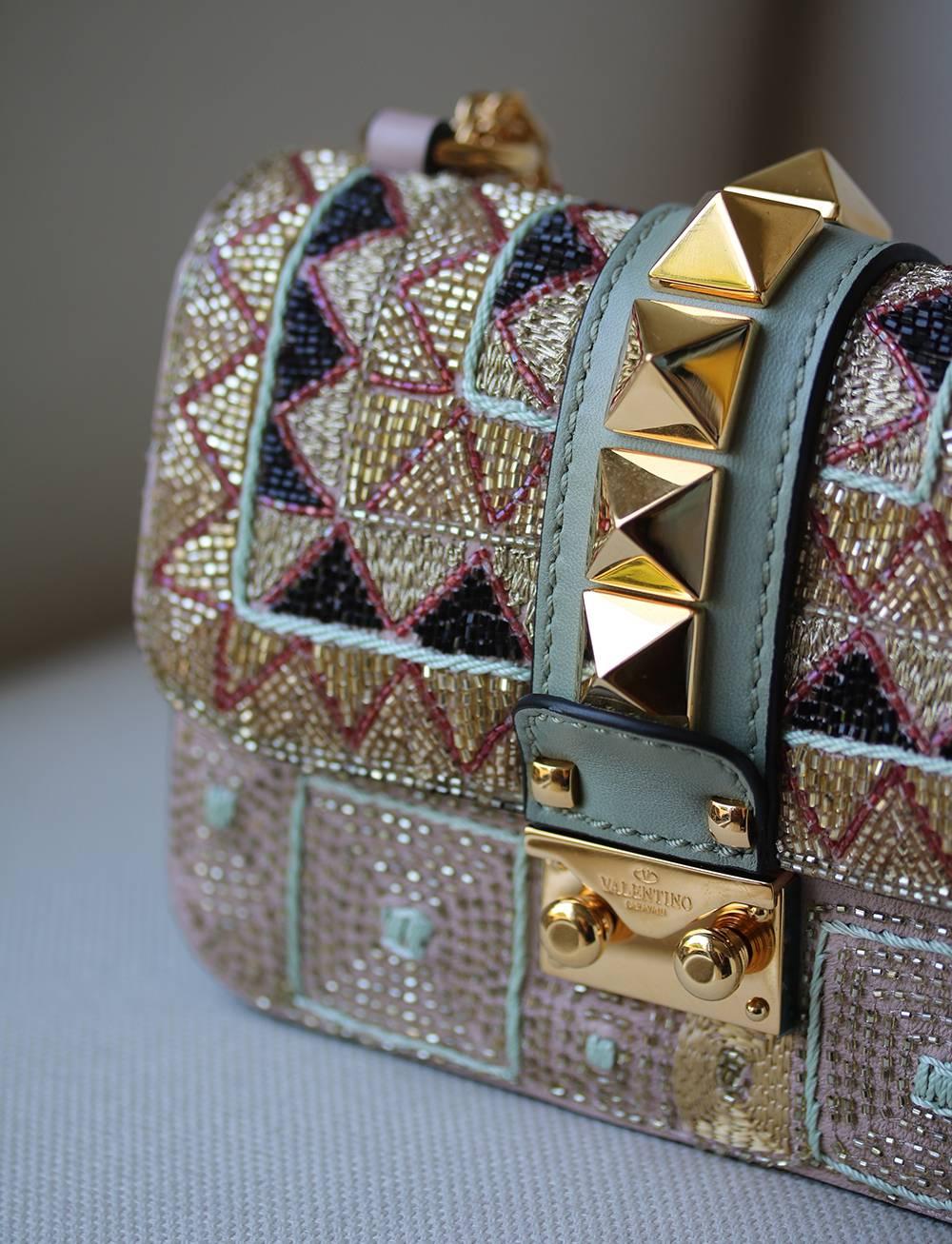 Valentino Garavani And Zandra Rhodes Draw Inspiration From The Label's Archive To Presnt This Collection With New Seasonal Patterns. Staying Iconic With A Row Of Gold-Tone Rockstuds Along The Centre Front, This Crossbody Depicts The Label's Dark