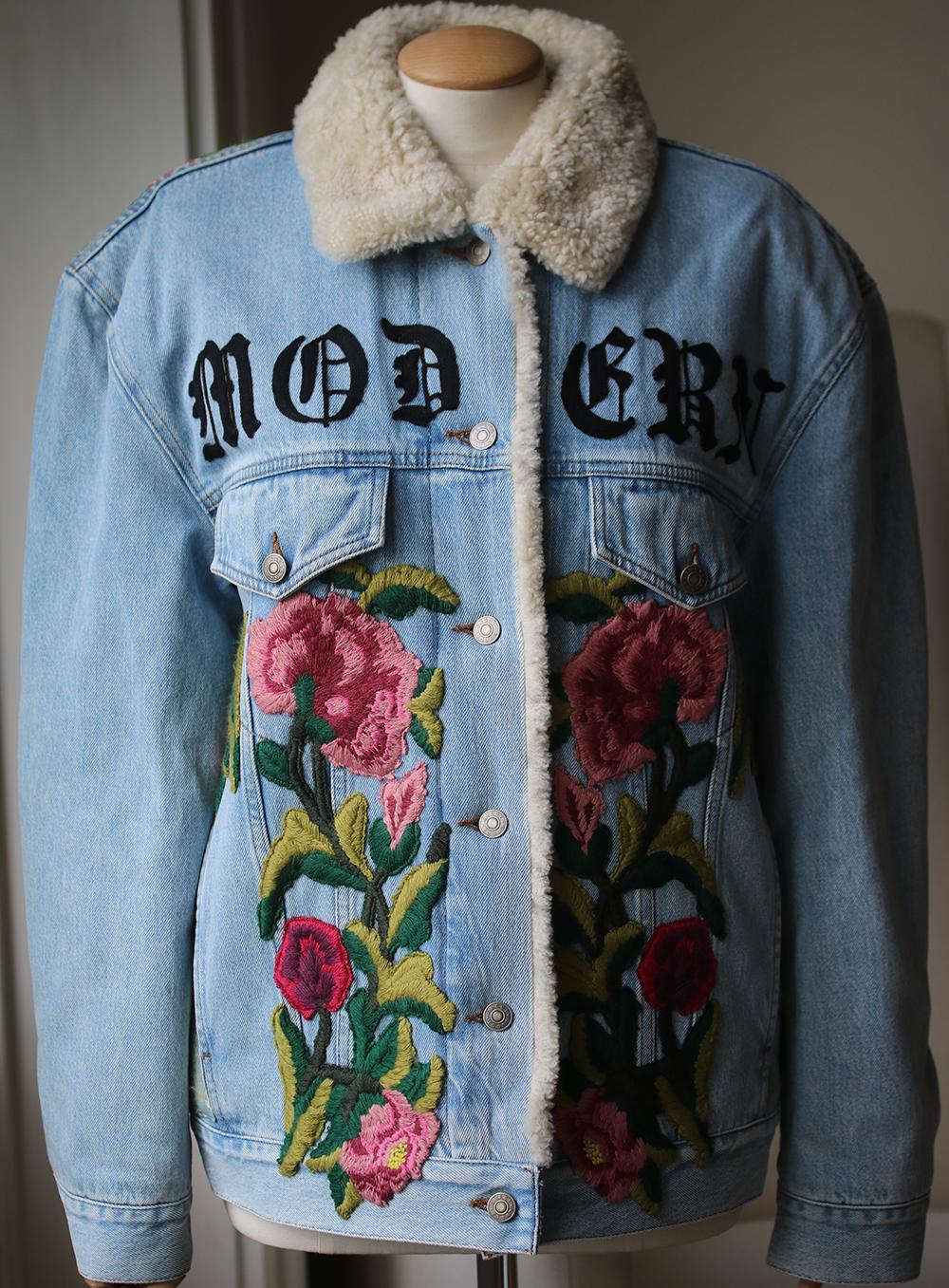 Gucci's oversized shearling-lined denim jacket has a cool, customized look. The jacquard panel at the back is intricately embroidered by hand with florals and a flaming mythical creature - each piece takes an artisan hours to complete. The gothic