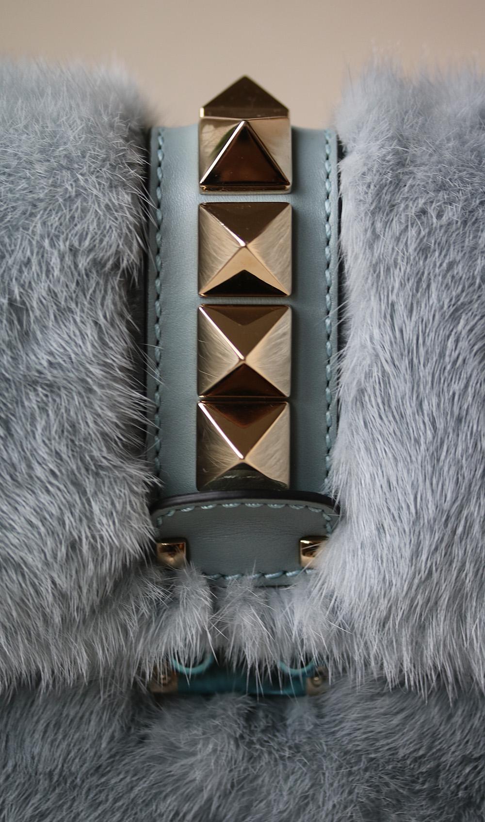 Valentino Garavani's Lock Small shoulder bag, a fan favourite, is back in a lush and dense mink fur design. The blue hue is complemented by blue leather trims and the iconic golden Rockstuds. Material: mink fur. Trim: leather, platinum-plated studs.
