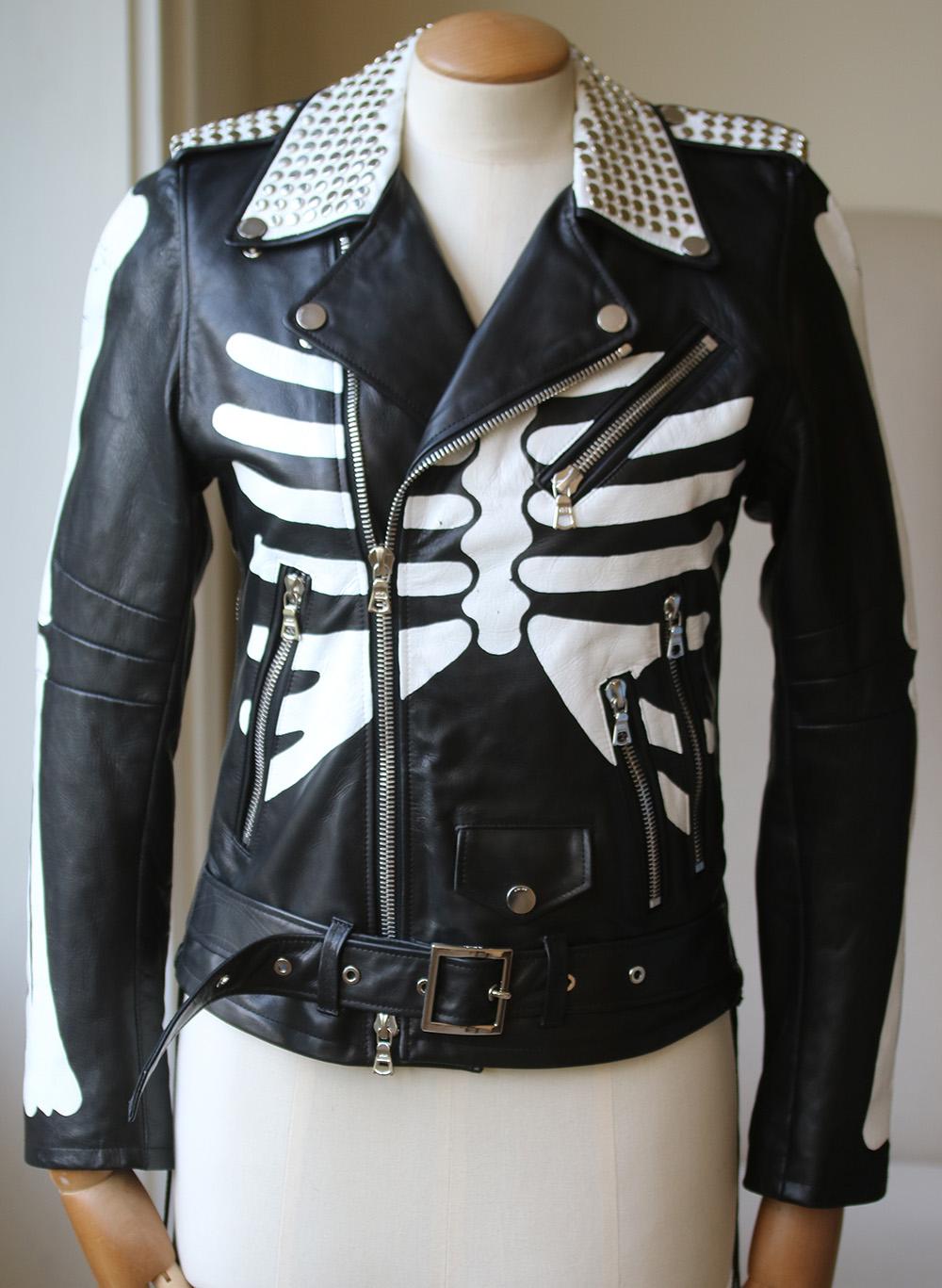 Painted with a white skeleton design, AMIRI's black leather moto jacket is detailed at the collar and epaulettes with flat studs. Snap-back notch lapels. Snap epaulettes. Four zip front pockets. Snap flap front pocket. Self-belt loops. Gusseted zip