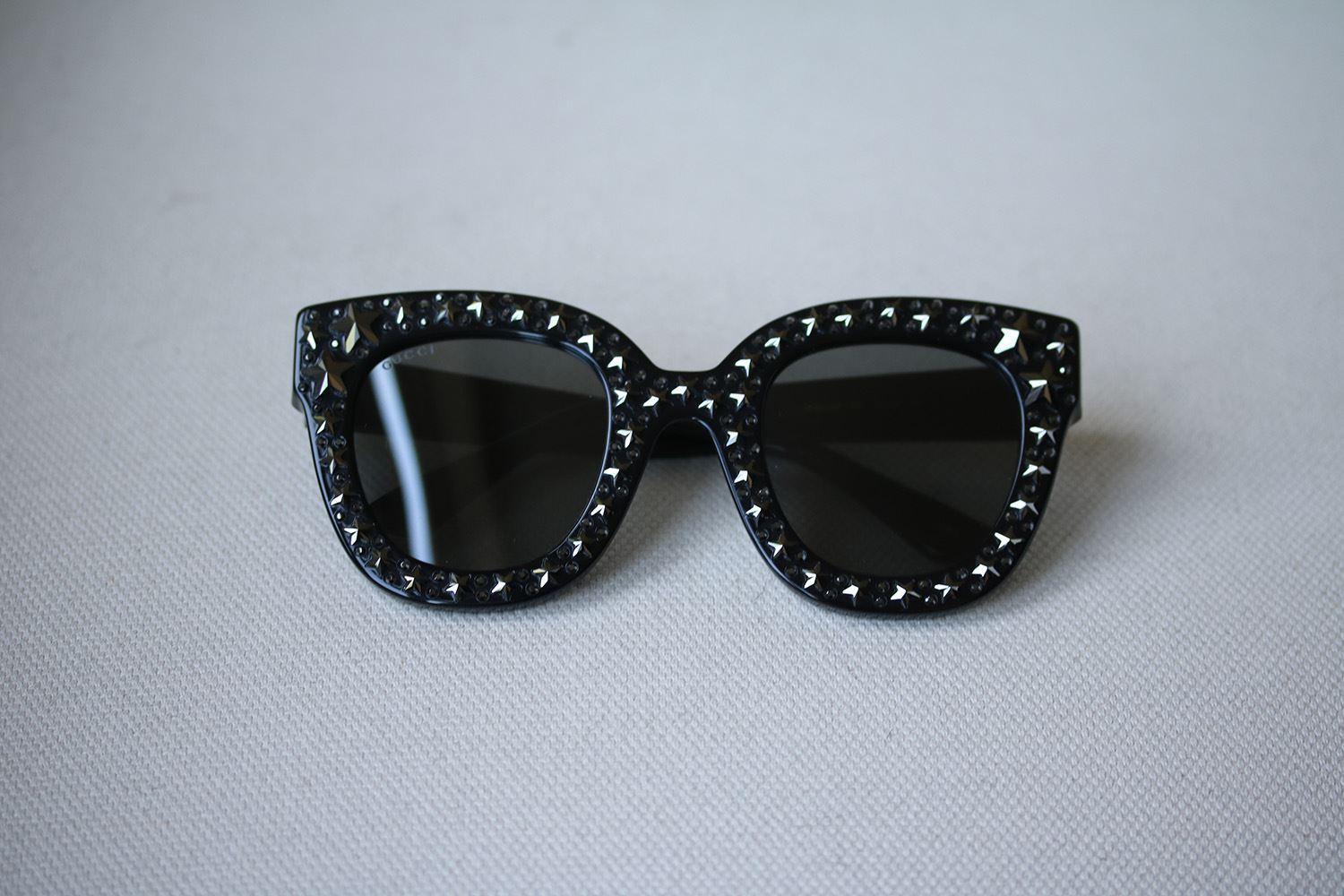 Black acetate frame with silver star-shaped crystals. Black acetate temples with silver star-shaped crystals and metal interlocking G. Grey lens. 100% UVA/UVB protection. Made in Italy.

Lens size - 49 mm
Arm size - 140 mm
Bridge size - 28