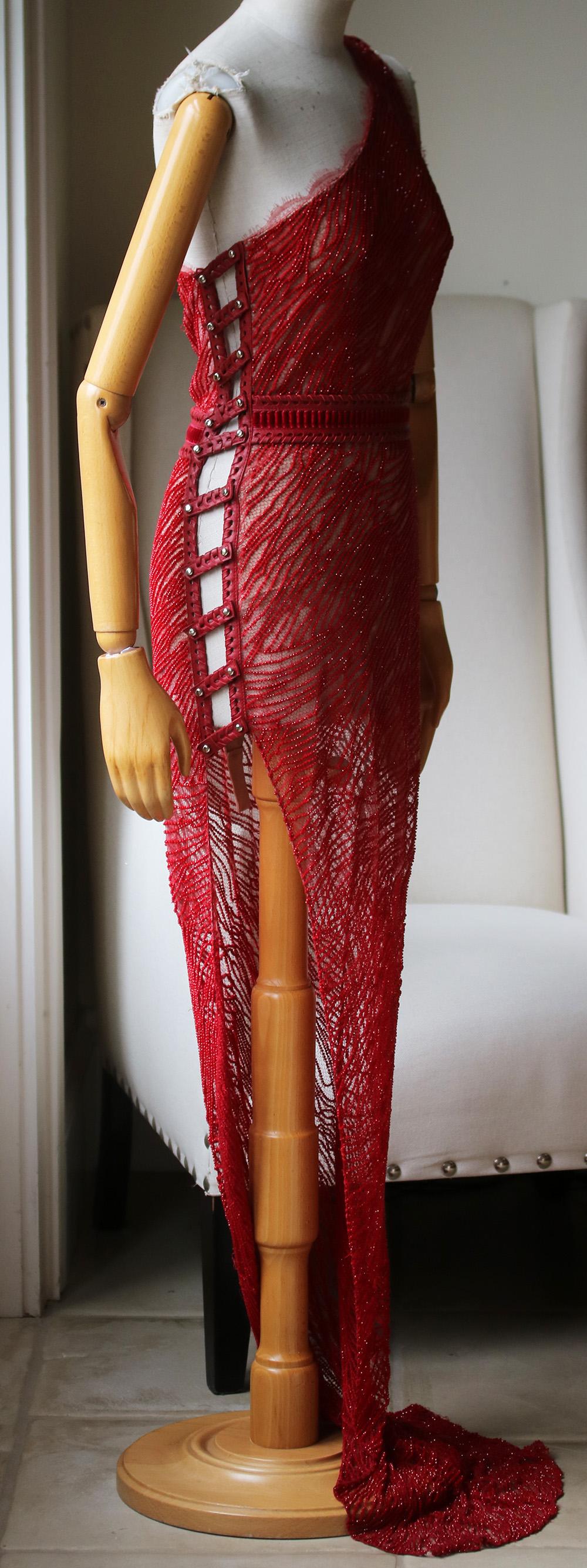 Custom made Aadnevik red crystal beaded lace dress. Built in bodysuit. Cut-out and slit detail down the side with removable leather fastening. Extra leather fastenings varying different sizes attached. The size can be altered. Leather and velvet
