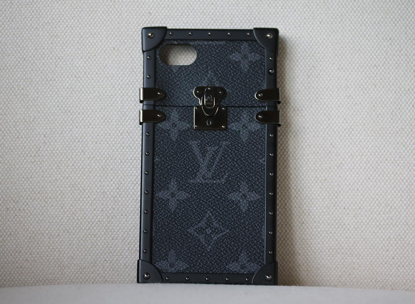 Louis Vuitton Monogram Eclipse Eye-Trunk iPhone 7 Plus Case. This stylish case is finely crafted of monogram coated canvas in black and gray and is styled after the iconic Louis Vuitton trunk. The case holds an iPhone 7 plus perfectly with a black