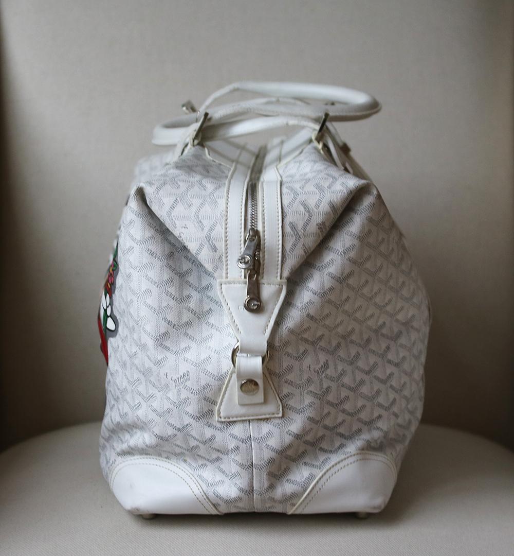 White chevron bag with hand painted design commissioned by Boyarde. Goyardine coated canvas Goyard Boeing 45 with white leather trim, tonal stitching, silver-tone hardware, yellow canvas lining, lock and key, zip pocket at interior wall and top zip