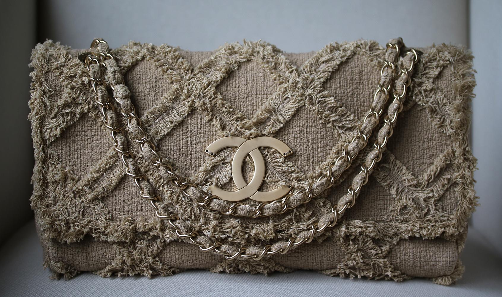 Chanel Fringe Trim Flap Bag Quilted Tweed. Constructed in beige quilted fringed tweed with gold-tone brass hardware. This flap bag features an oversized CC logo at the front with chain strap enabling it to be worn on the shoulder or as a cross-body.