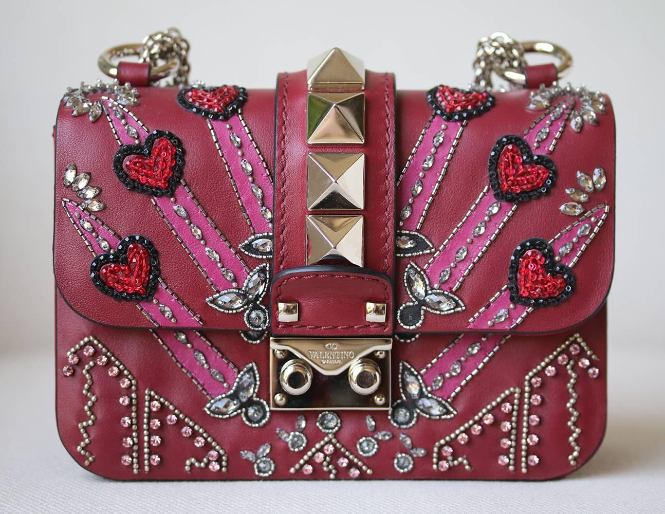 Valentino Garavani And Zandra Rhodes Draw Inspiration From The Label's Archive To Present This Collection With New Seasonal Patterns. Staying Iconic With A Row Of Marcro Rockstuds Along The Centre Front, This Crossbody Depicts The Label's Dark
