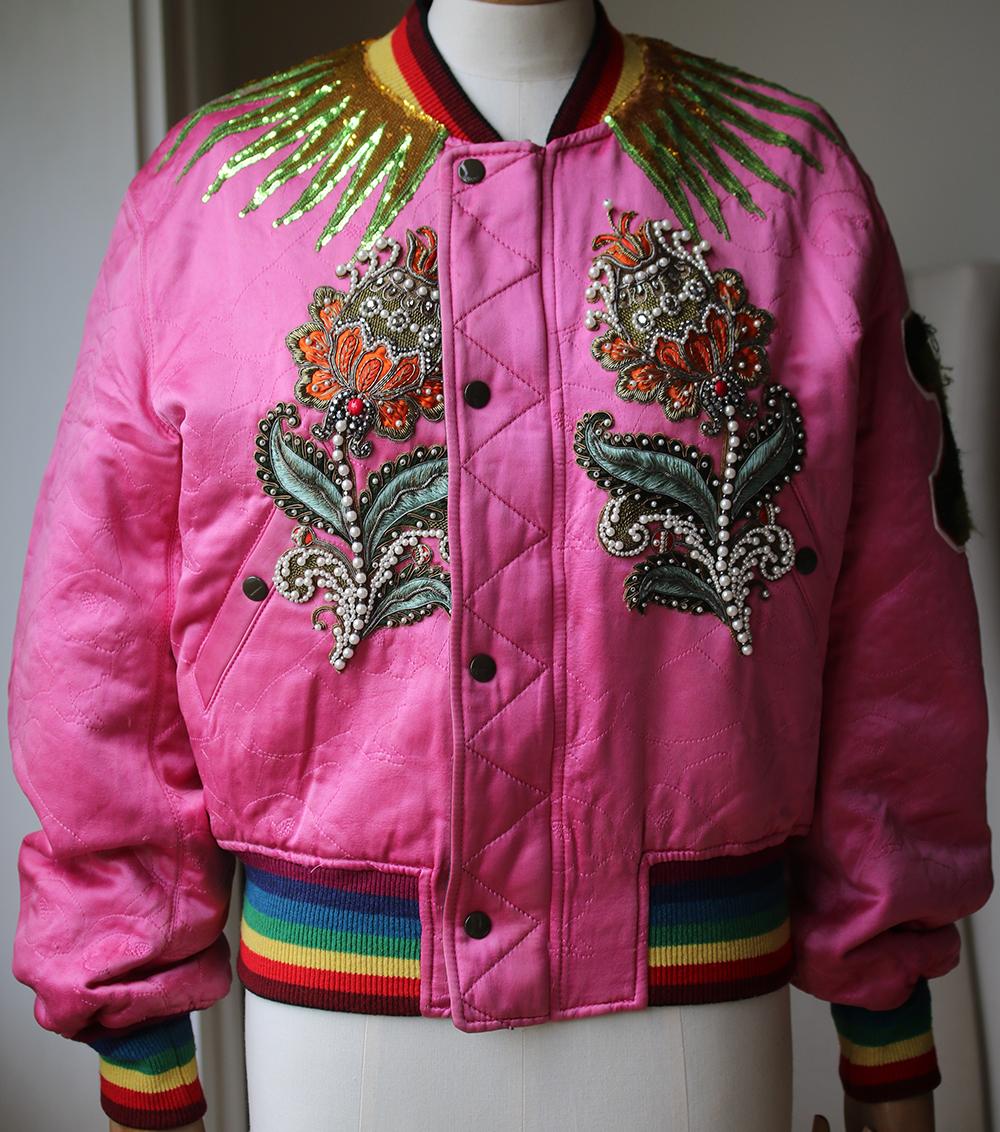 Reversible long sleeve textured satin bomber jacket in pink featuring tonal graphic pattern embroidered throughout. Multicolour embroidered cross-stitched and terrycloth appliques featuring faux-pearls sequins metal embroidery and crystal-cut