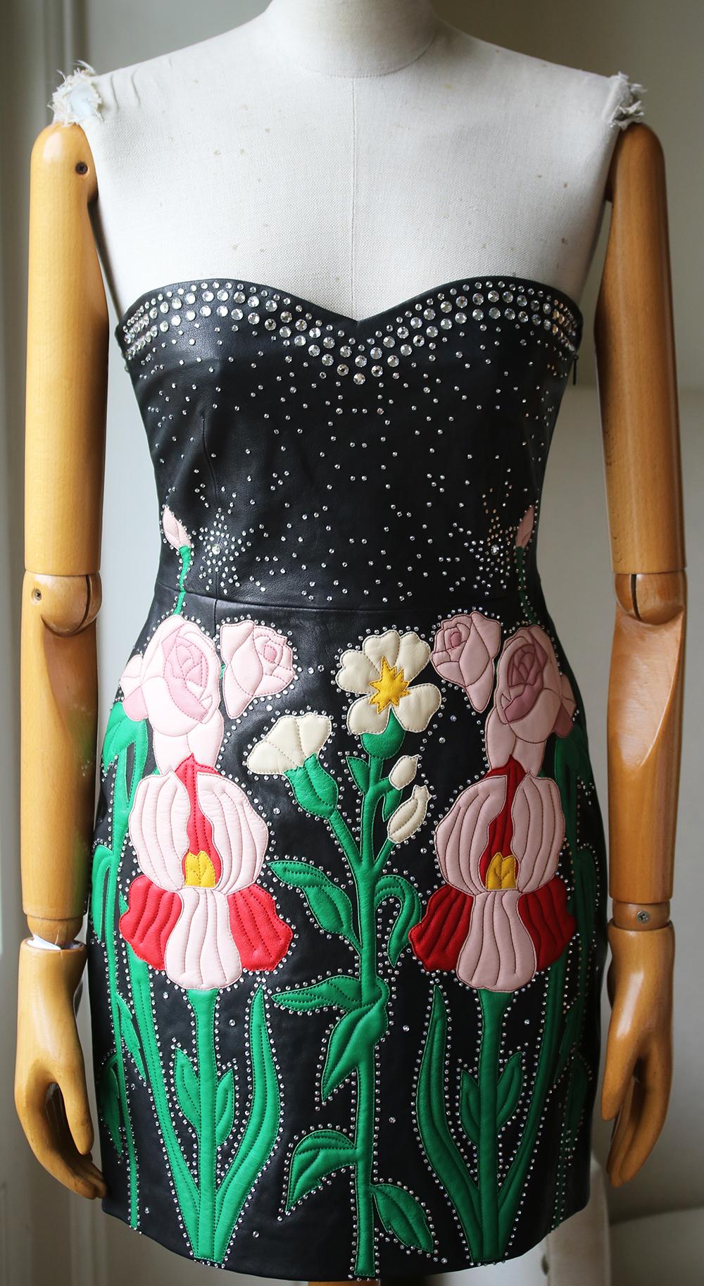 Leather flower intarsia and stud details elavate this dress. Sweetheart neckline. Strapless. Side zip closure. Lined. Made in Italy. 100% Leather. Lining: 91% silk.

Size: IT 40 (UK 8, US 4, FR 36)

Condition: As new condition, no sign of wear.