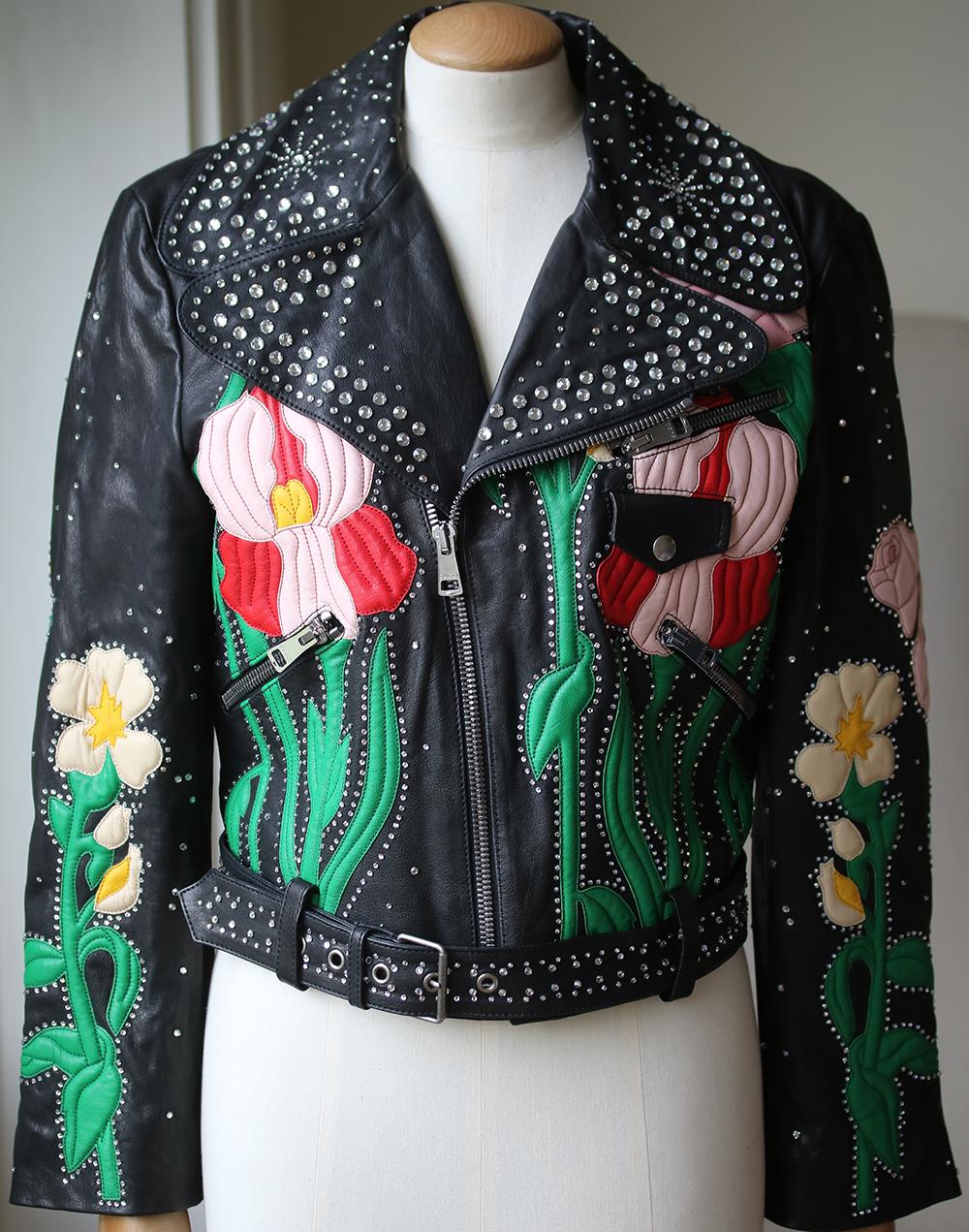 A couture-like collector's piece produced in limited numbers, Gucci's leather biker jacket has been hand-painted and hand-embroidered with leather flowers and crystal studs – each one is totally unique. Slim-fit design is lined in a lustrous red