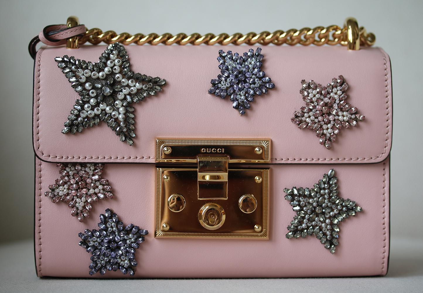 Gucci's 'Padlock' bag has been made in Italy from pink leather in a structured shape - though small, it will comfortably fit your phone, cardholder and a few cosmetics. This style is embellished with faux pearls and crystals in the shape of stars.