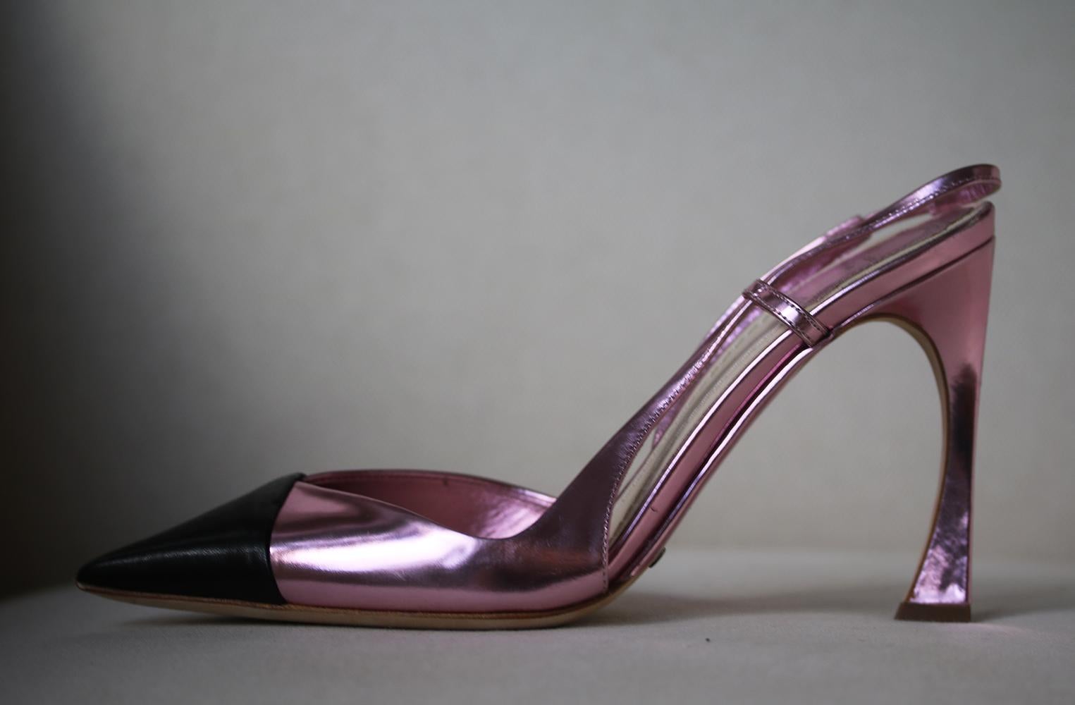 These Christian Dior metallic pink and black leather heels are for the fashion forward, featuring a high heel detail with cut-outs, a pointed-toe and a leather slingback design.

Size: EU 37 (UK 4, US 7)

Condition: New without box. 