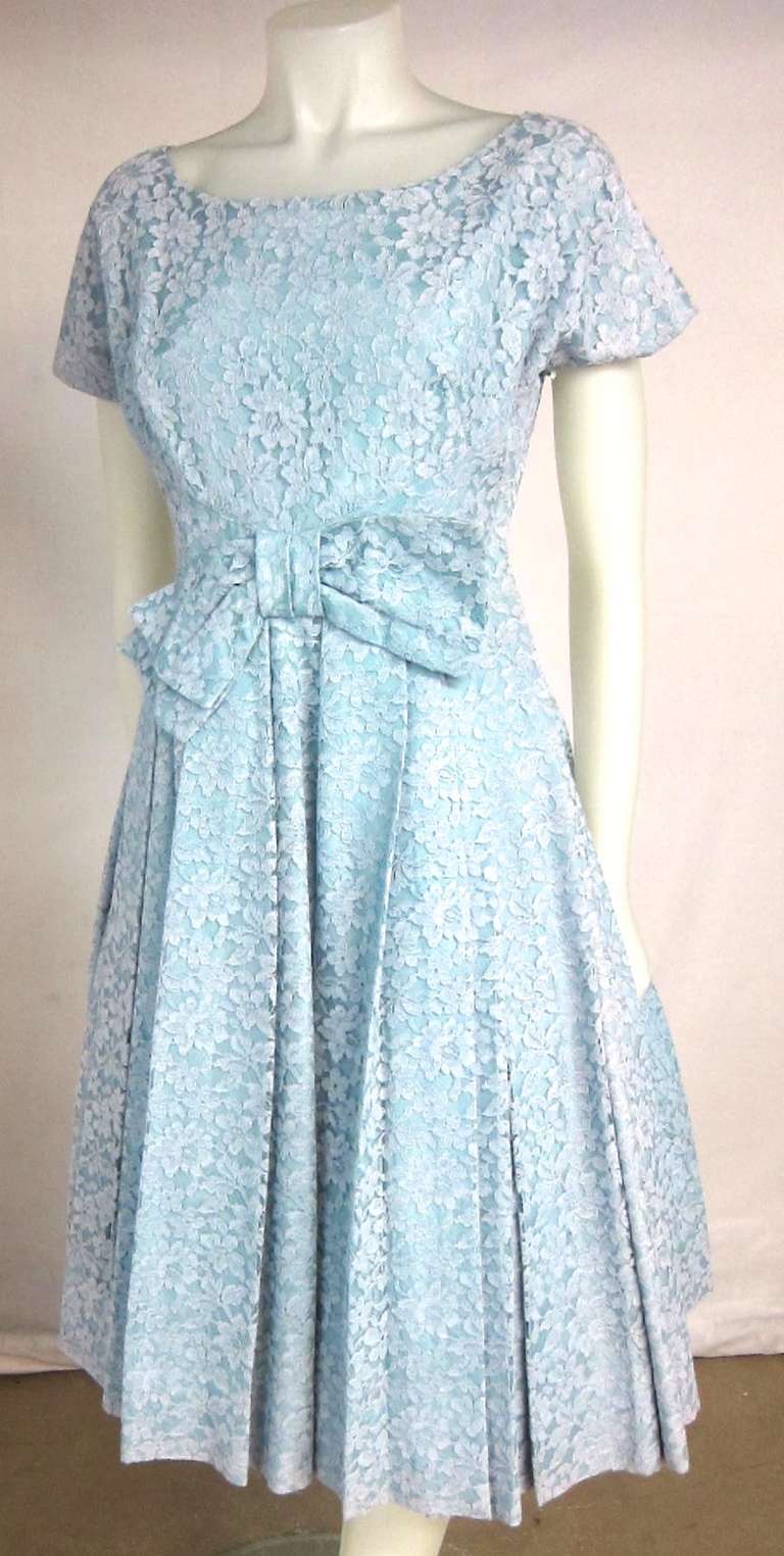 Gorgeous Blue lace dress with big bow at the waist. The lace has a hint of pink. It is lining and has a wonderful swoosh sound!  Has a side metal zipper. 

Bust: 36