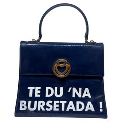 Eine ikonische blau-weiße Handtasche aus den 1980er Jahren von Franco Moschino " Te du na bursetada! "