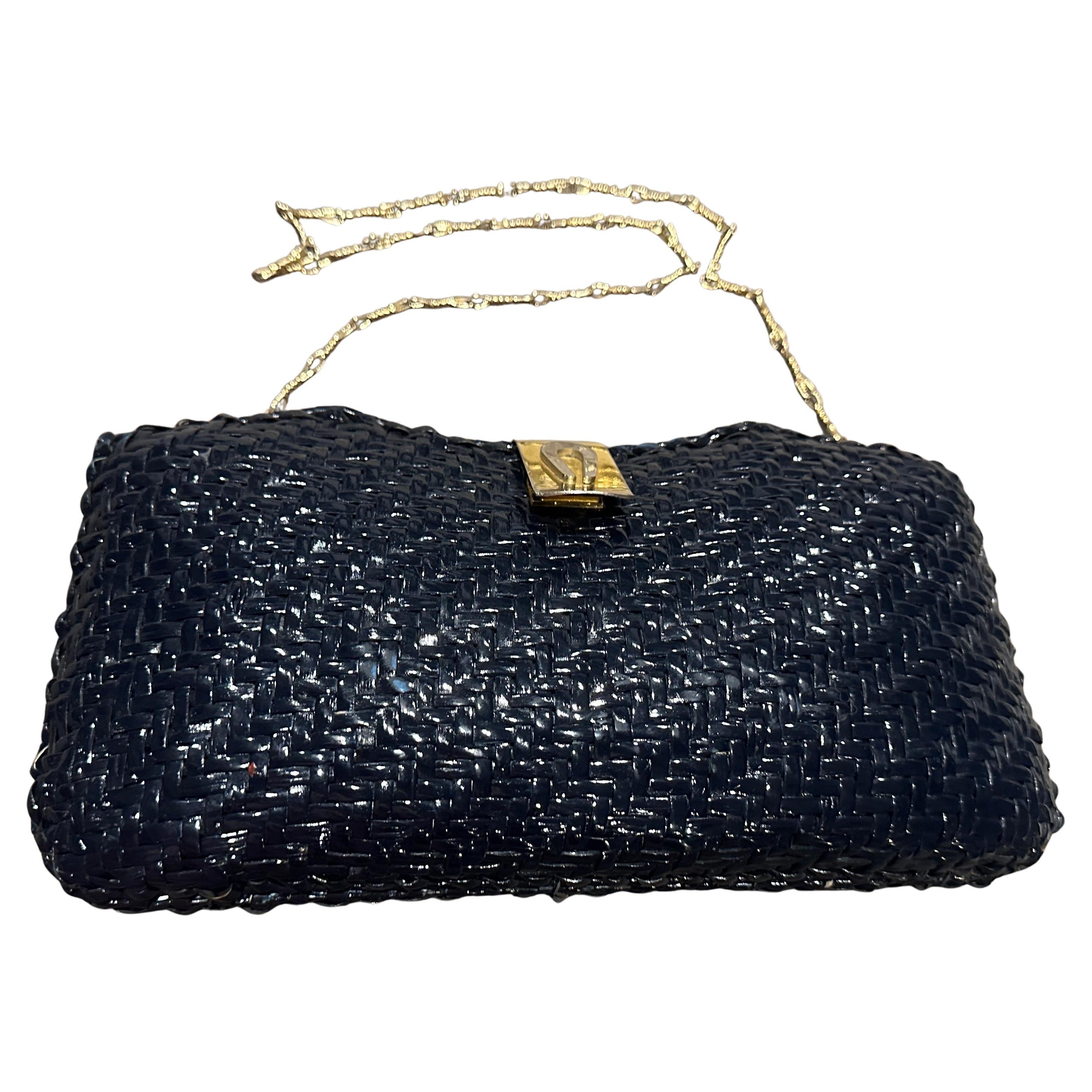 Squisita borsa a tracolla in vimini blu navy degli anni '50 con hardware a doppia tonalità
Scopri un pezzo accattivante dell'artigianato italiano di metà secolo con questa squisita borsa a tracolla degli anni '50. Questo affascinante accessorio è