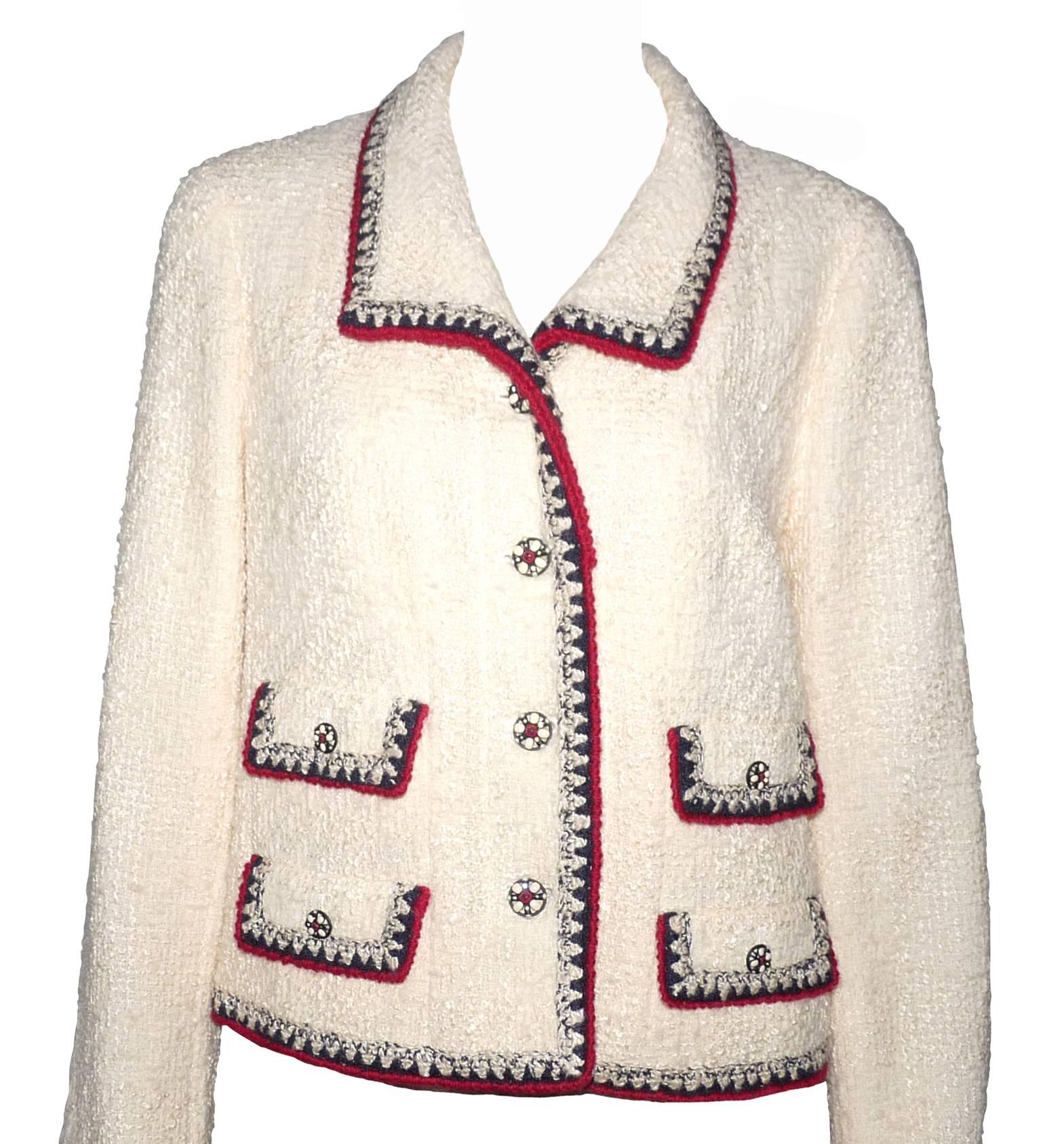 EXCEPTIONAL Chanel Jacket 
Tweed woven cream colored with navy and red woven.
Engraved metallic and enamel pearls and CC logo
4 small pockets.
Removable cuffs in navy cotton.
Ivory camellia stretch silk lining
Composition: 80% wool, 8% silk, 8%